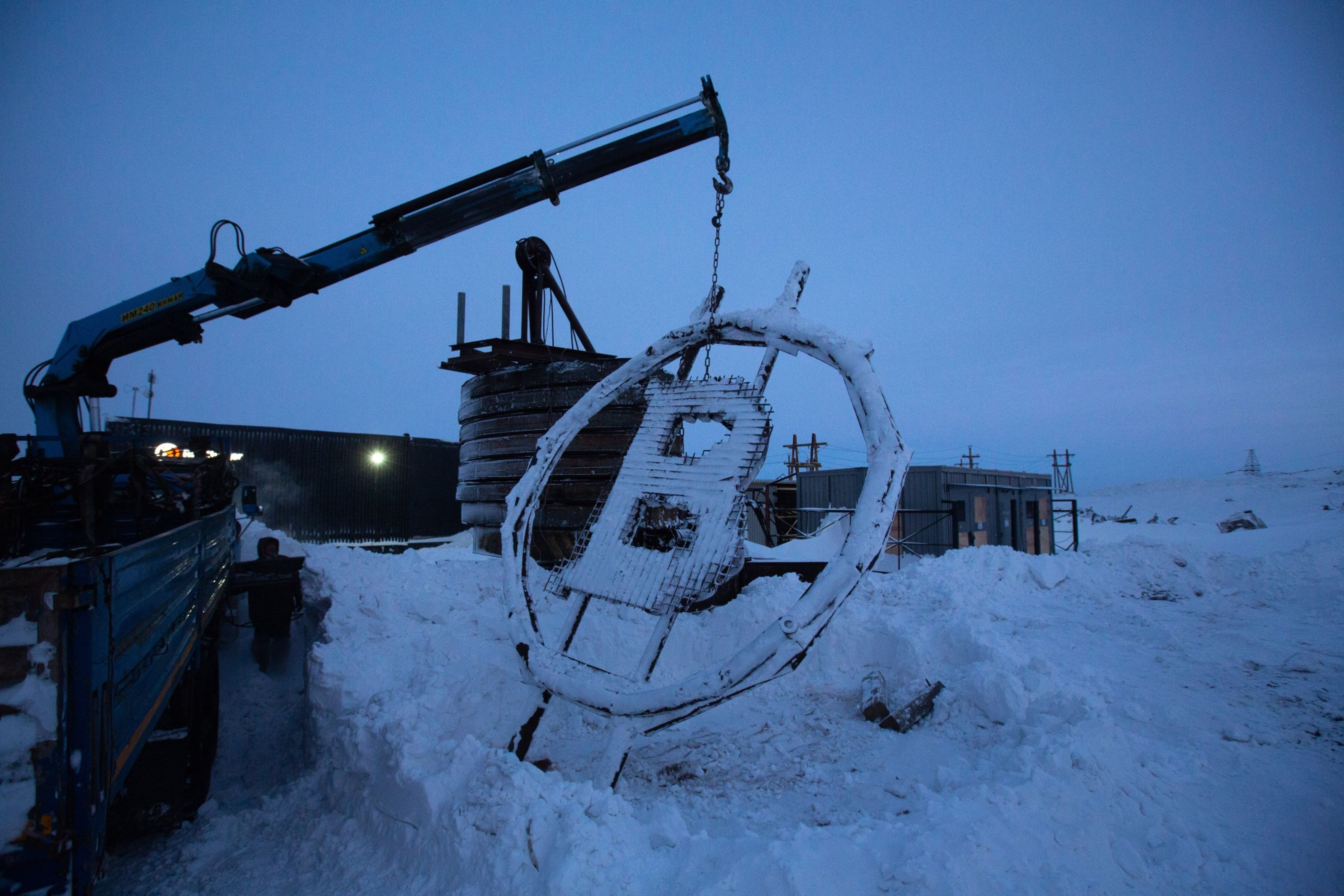 A crane arm lifts a bitcoin sculpture
