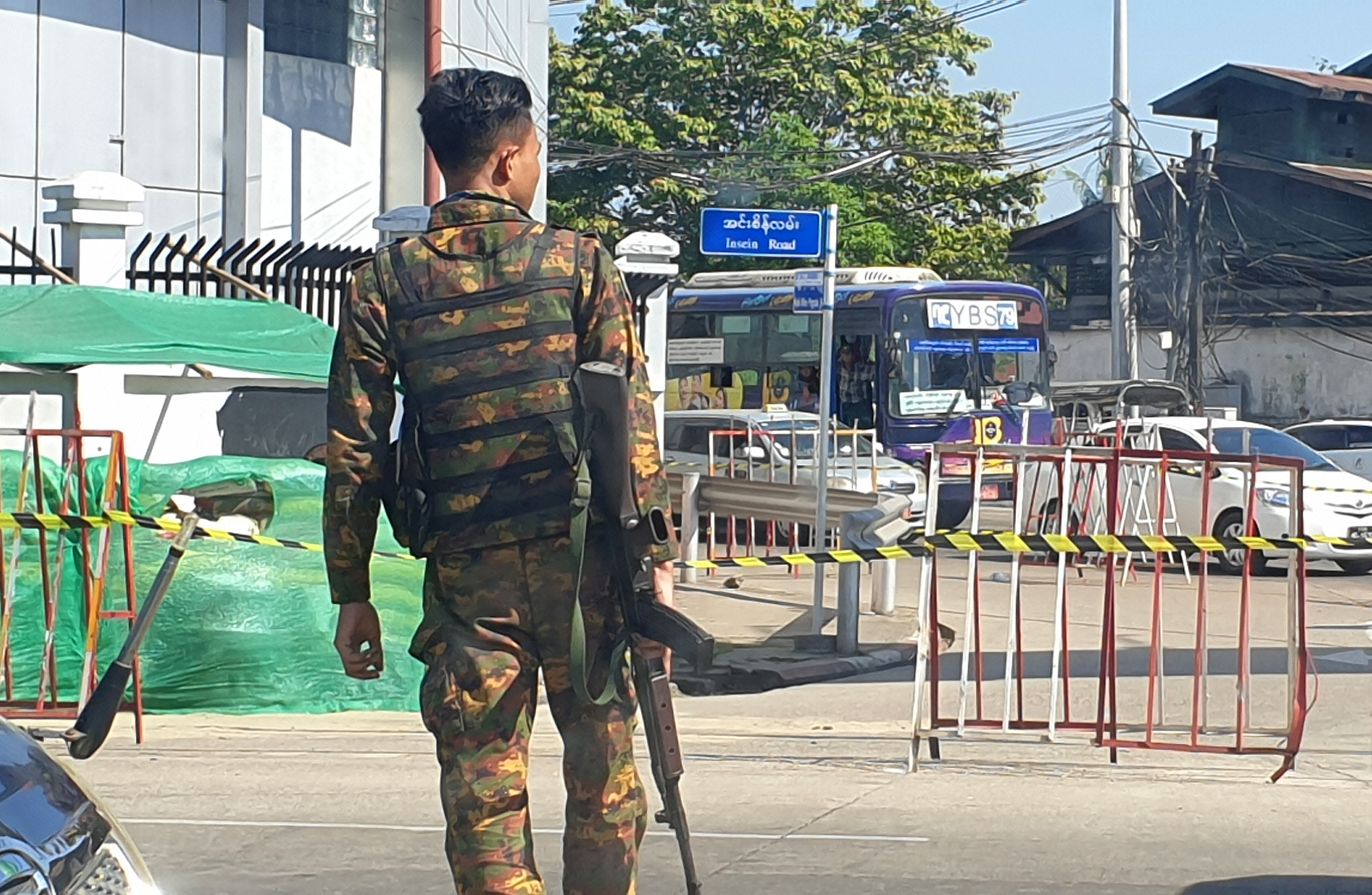 A member of the Myanmar armed forces, in uniform and armed, patrols a street in Yangon