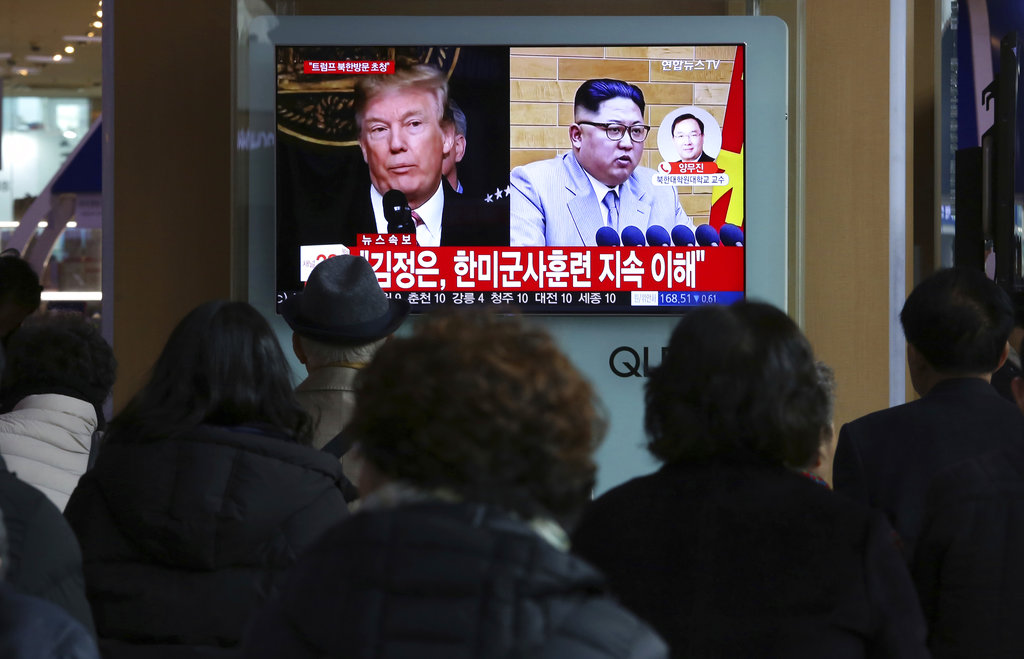People watch a TV screen showing North Korean leader Kim Jong Un and U.S. President Donald Trump in 2018.