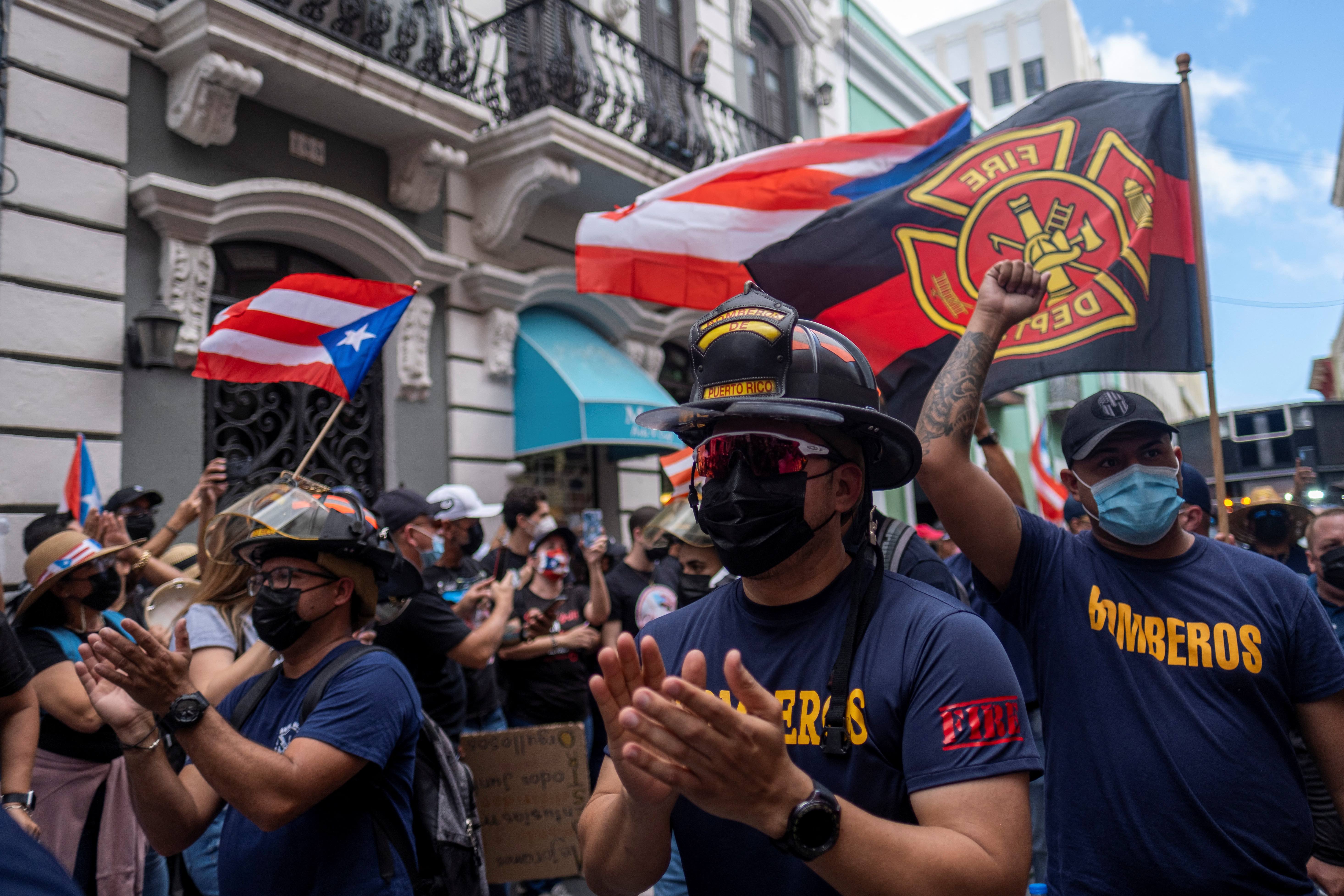 Puerto Rican firefighters participate in a march through the streets of Old San Juan during a teachers’ protest in San Juan, Puerto Rico