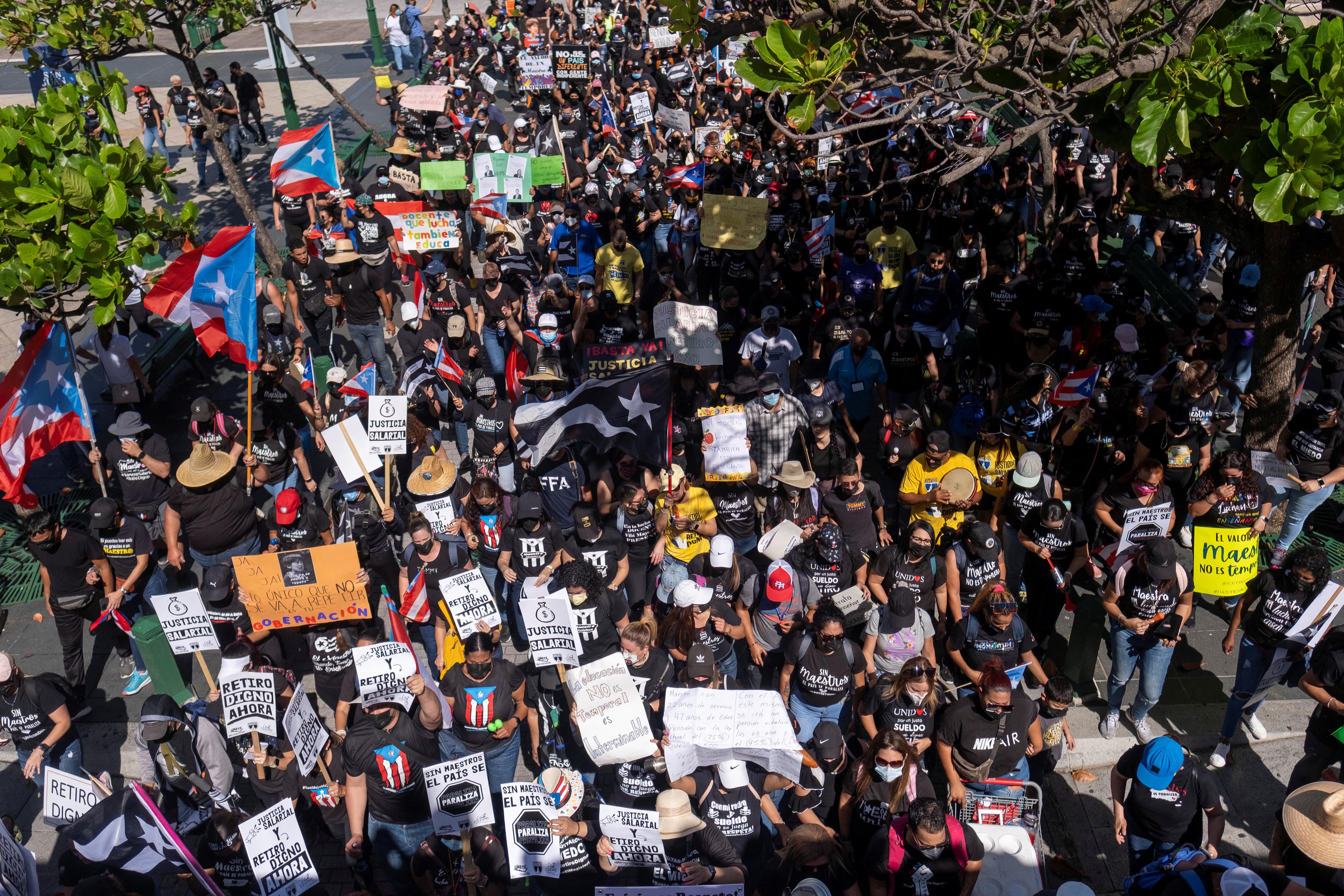 People march through the streets of Old San Juan during a protest of teachers demanding salary increases and better working conditions, in San Juan, Puerto Rico