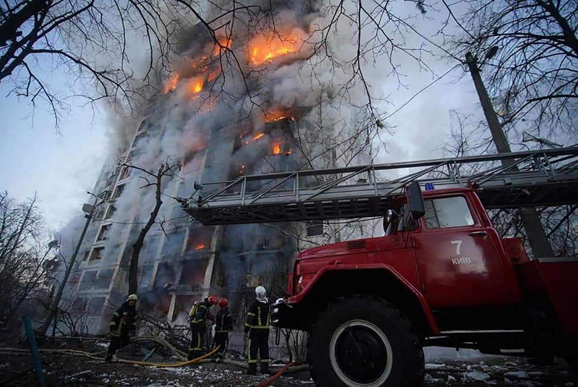 firemen work to extinguish a fire in a housing block