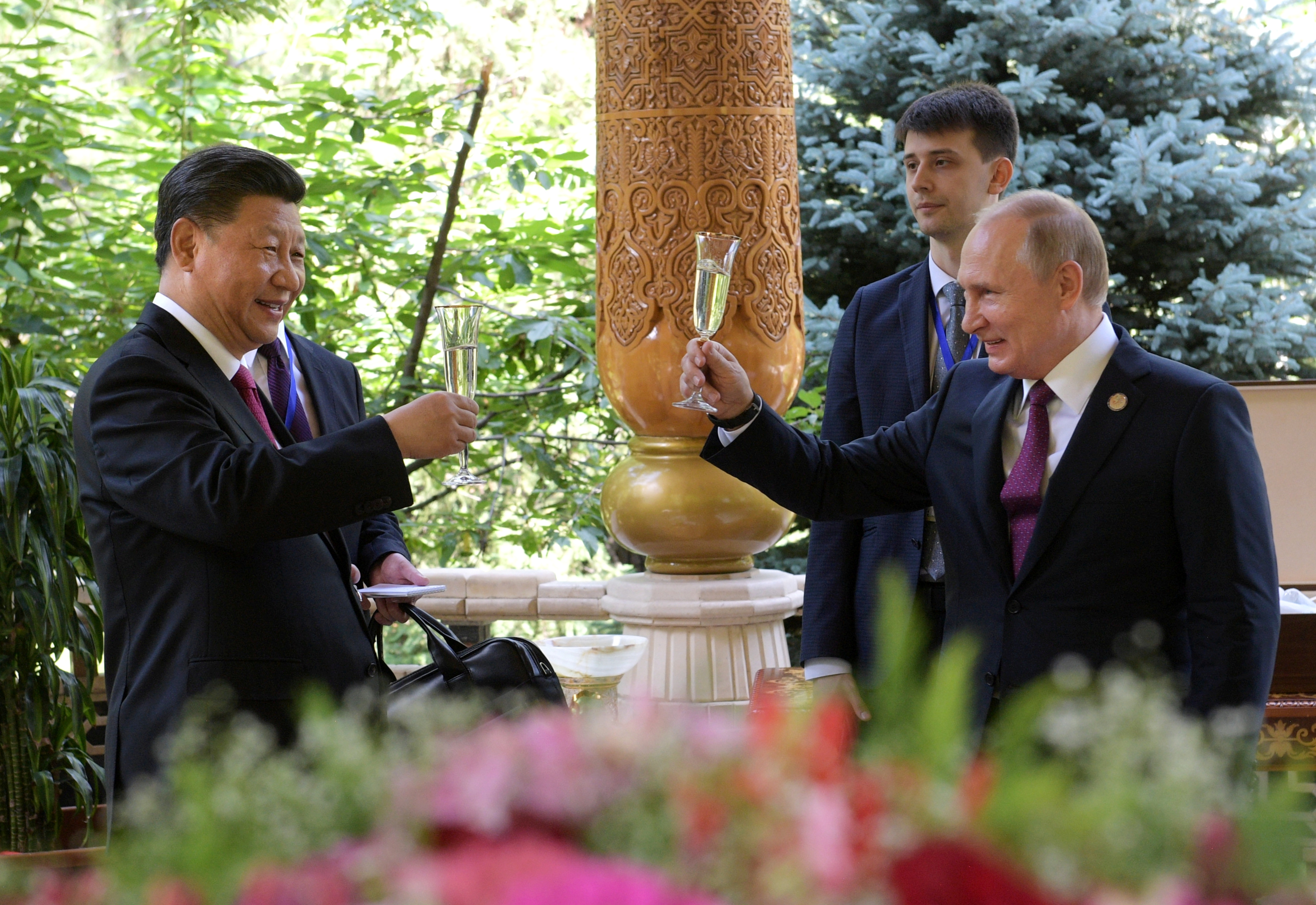 Russian President Vladimir Putin (R) toasts with Chinese President Xi Jinping while congratulating him on his birthday before the Conference on Interaction and Confidence-Building Measures in Asia (CICA) in Dushanbe, Tajikistan June 15, 2019.