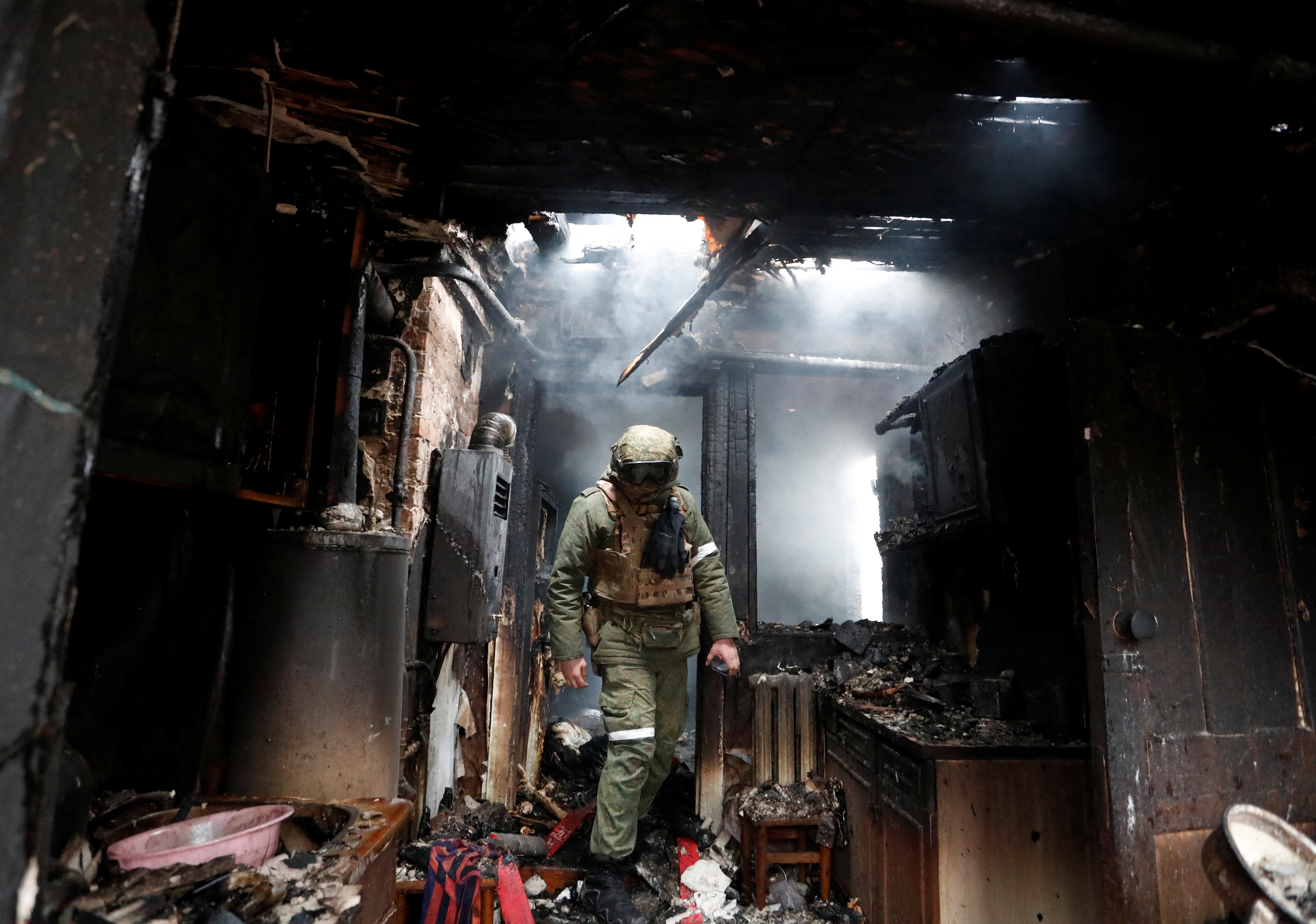 A serviceman of pro-Russian militia walks inside a house that was damaged by recent shelling, in the separatist-controlled city of Donetsk,