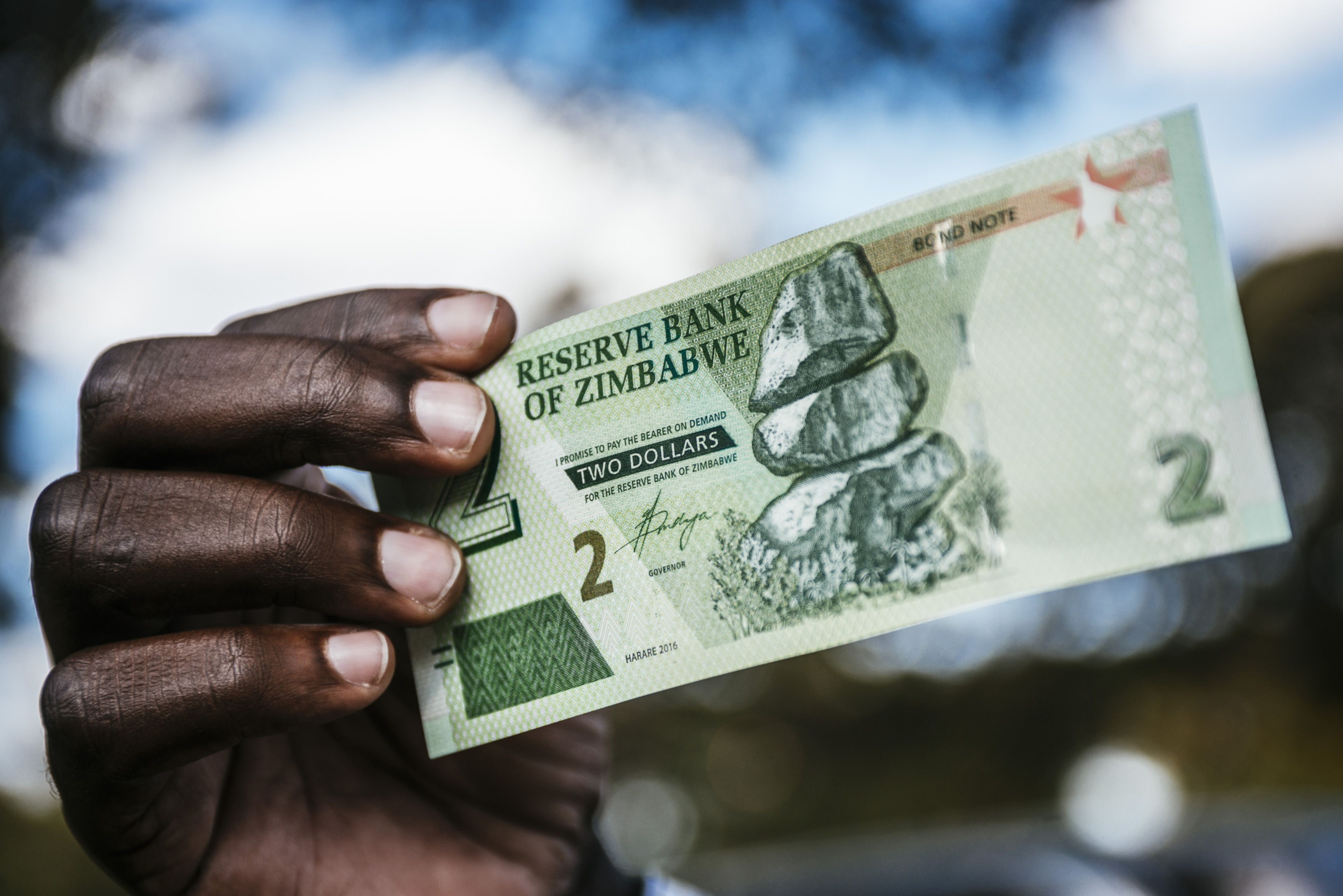 A man holds a Zimbabwean two-dollar bond banknote in Harare, Zimbabwe, in 2018