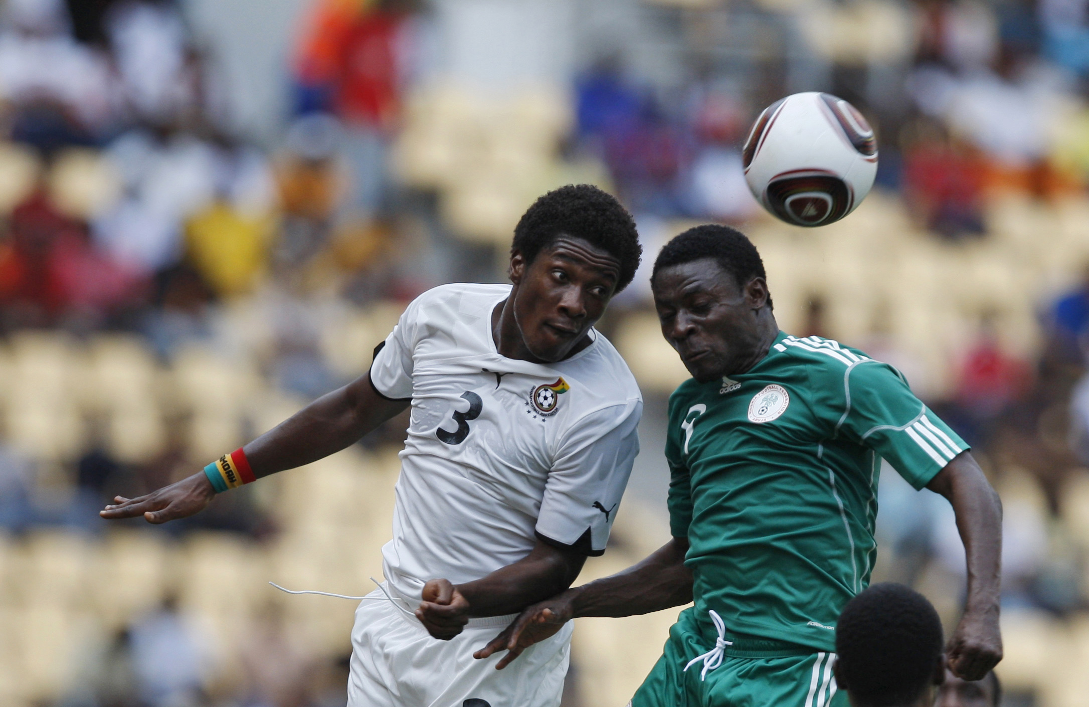 Ghana's Asamoah Gyan, left, challenges Nigeria's Obafemi Martins