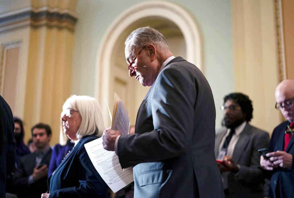 Senate Majority Leader Chuck Schumer looks over his notes before taking questions from reporters and speaking about the Russian invasion of Ukraine, at the Capitol in Washington.