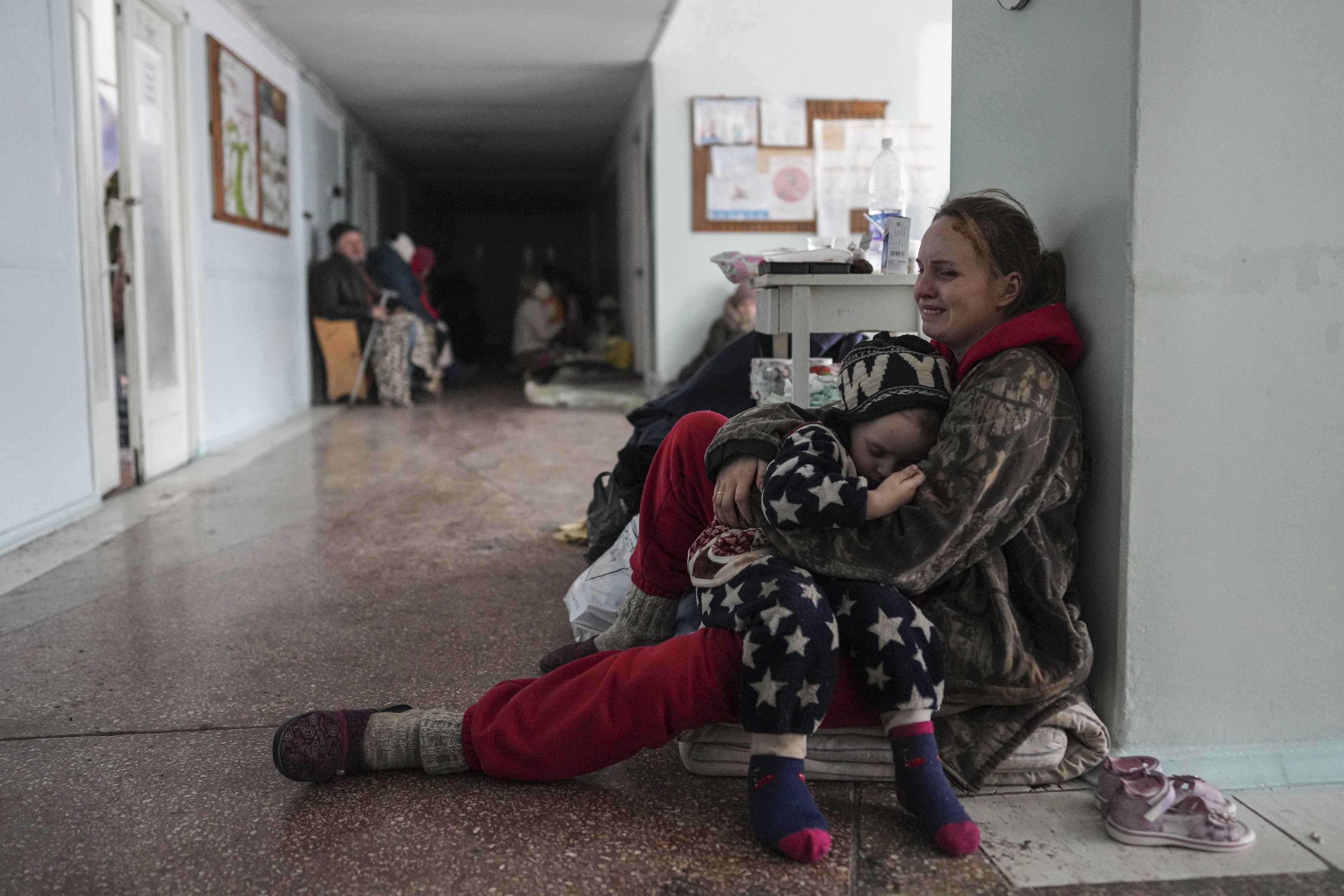 Anastasia Erashova cries as she hugs her child in a corridor of a hospital in Mariupol, eastern Ukraine
