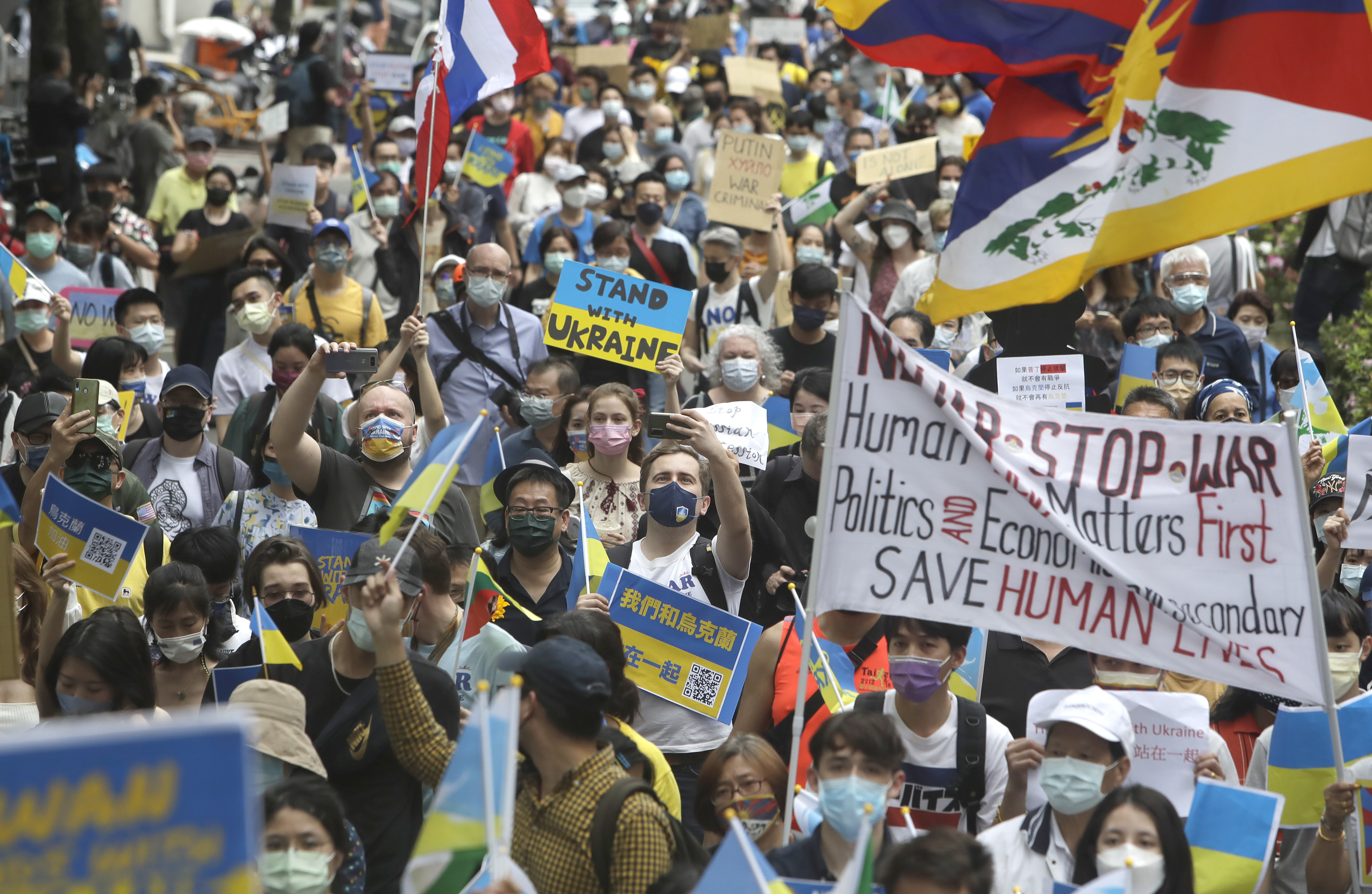 Crowds of people march in support of Ukraine waving the country's blue and yellow flag during a rally in Taipei on March 13
