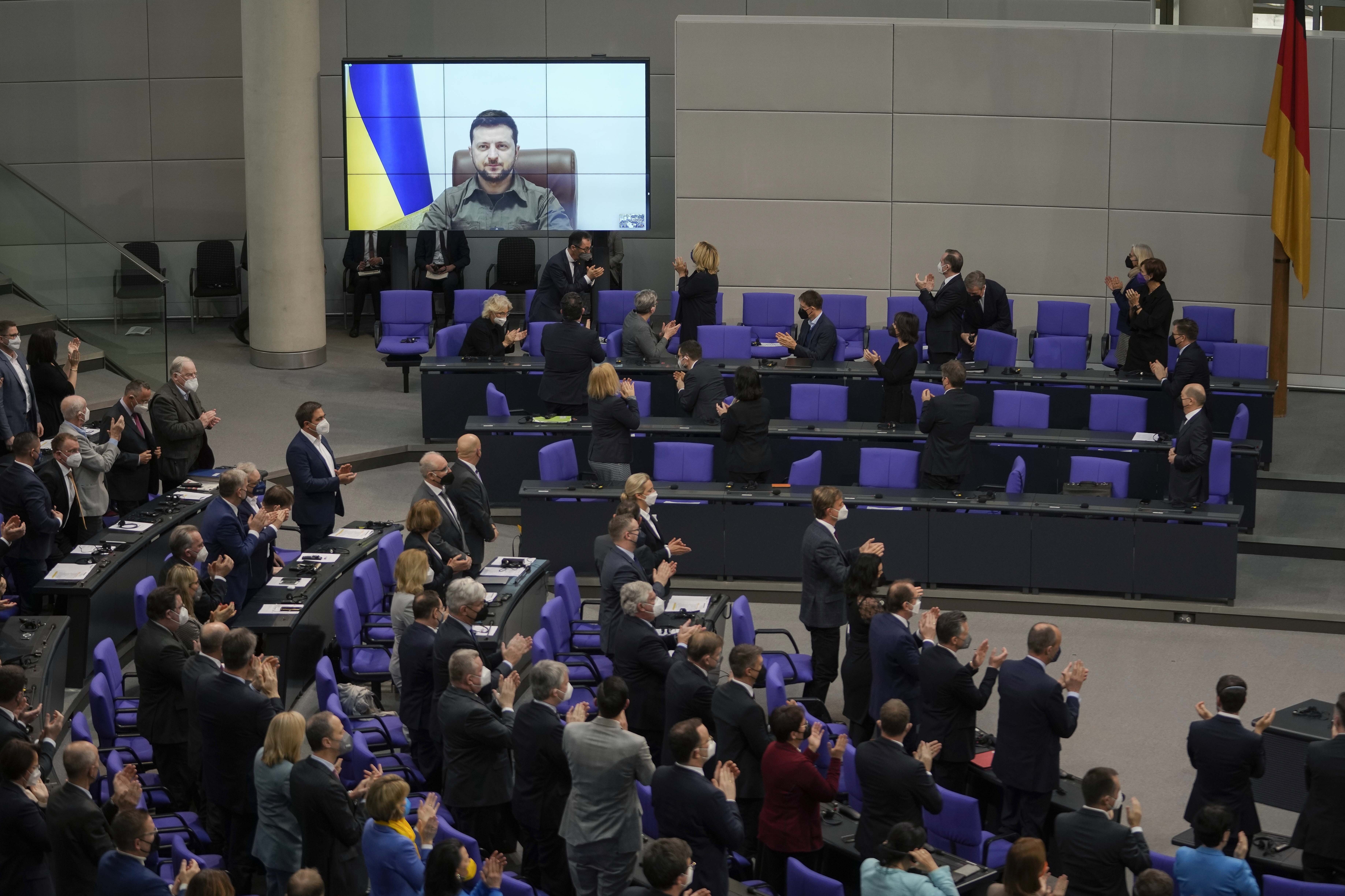 Members of the German parliament Bundestag give Ukraine President Volodymyr Zelenskyy a standing ovation before he speaks in a virtual address to the parliament at the Reichstag Building in Berlin, Germany