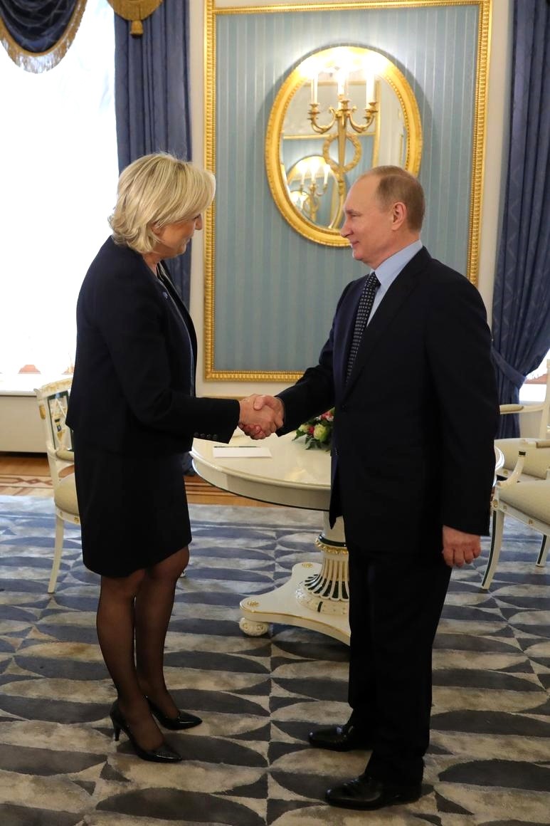 Le Pen and Putin shake hands before a meeting in Moscow in 2017