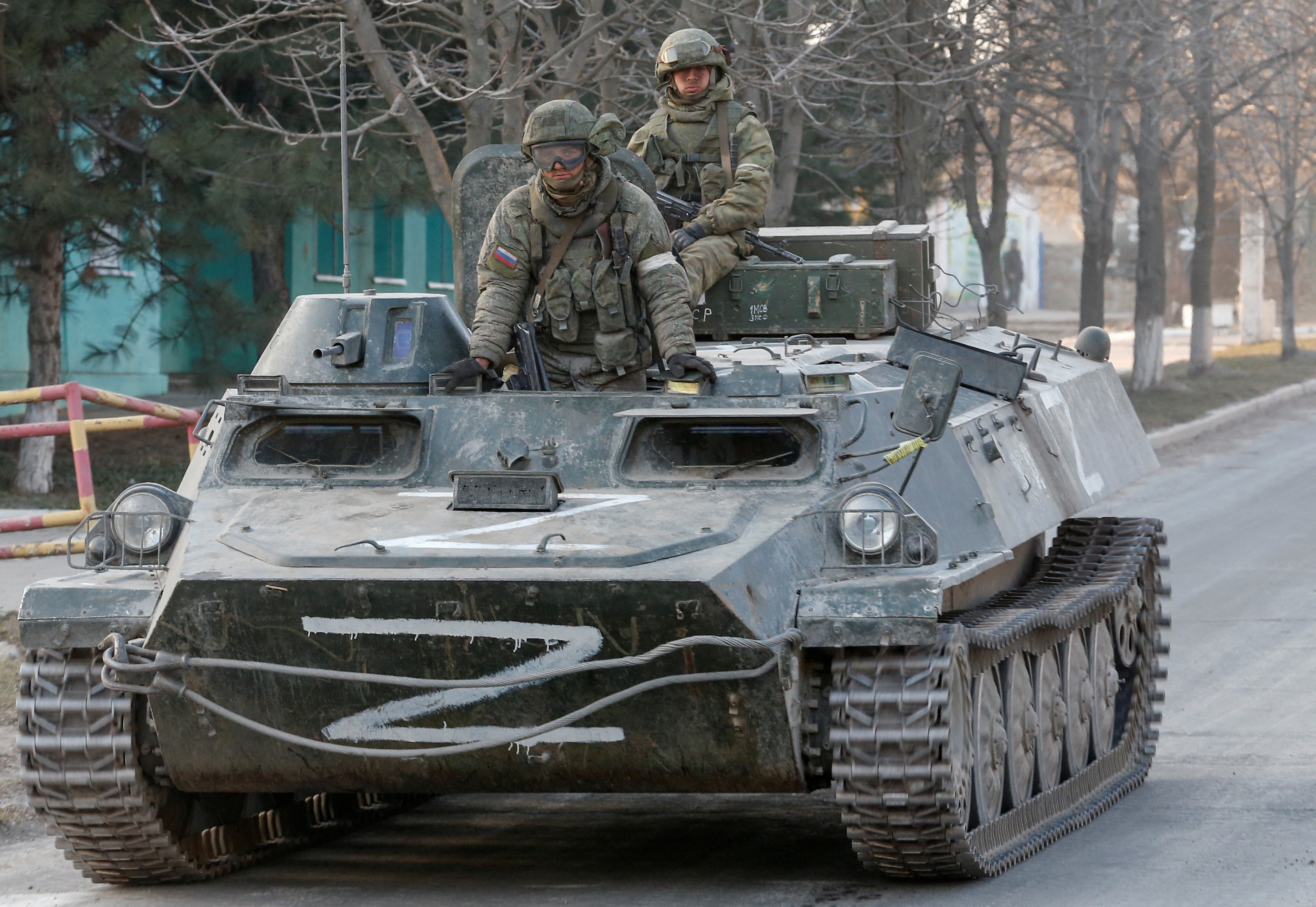 Russian troops are seen atop of an armoured vehicle with the symbols "Z" painted on its sides