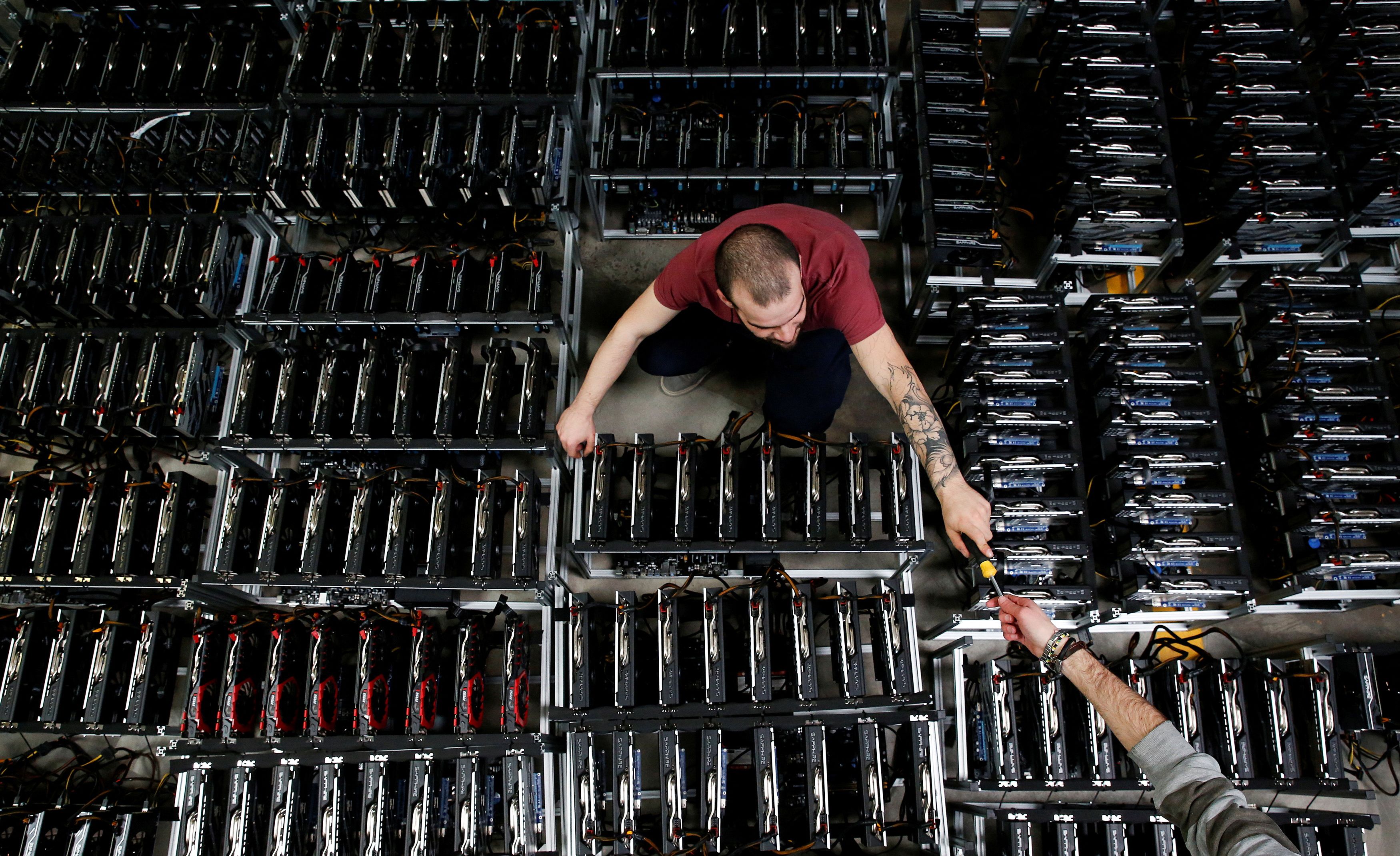 Employees work on bitcoin mining computers at Bitminer Factory in Florence, Italy