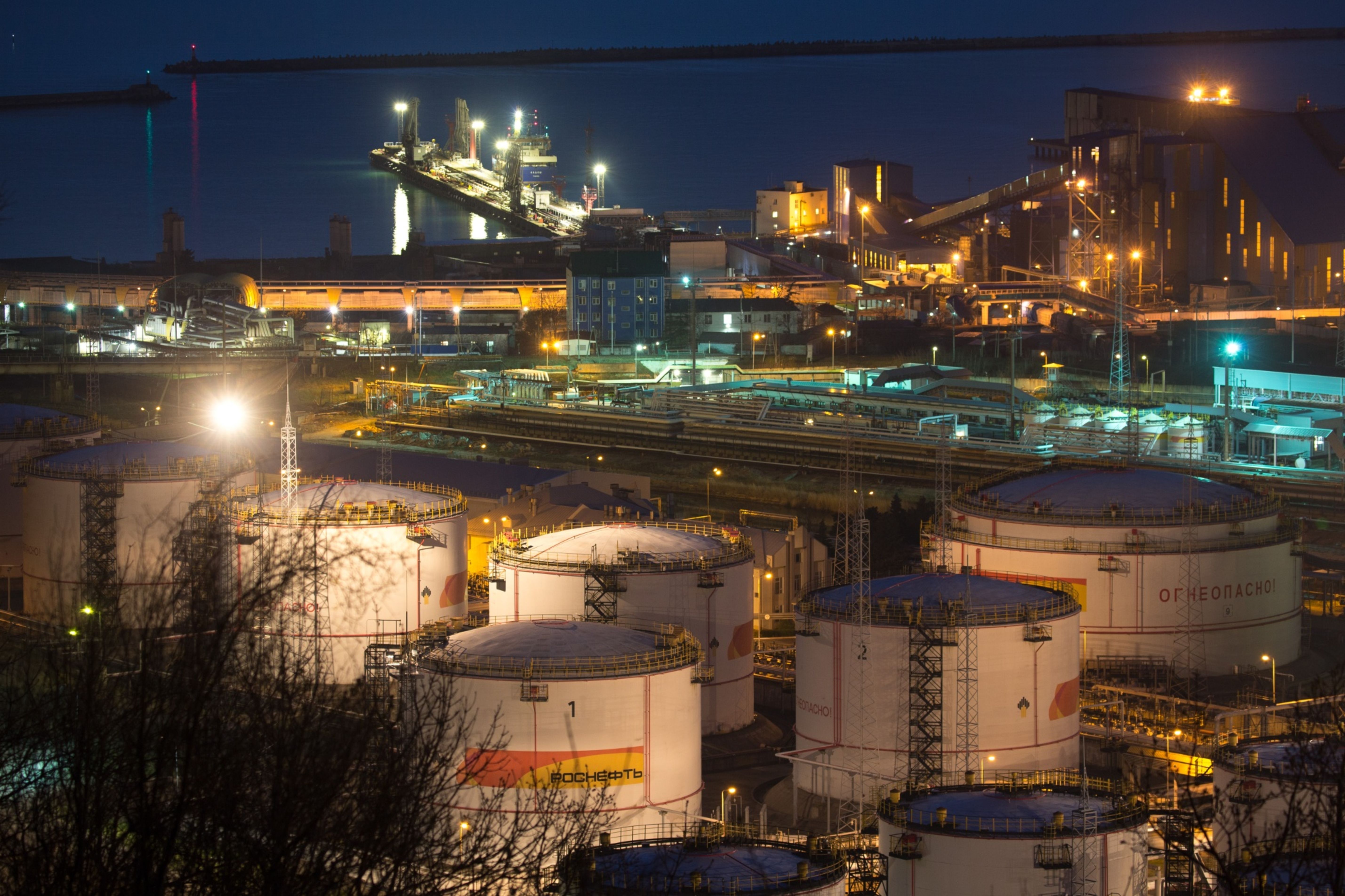 Oil storage tanks stand illuminated at night at the RN-Tuapsinsky refinery, operated by Rosneft Oil Co., in Tuapse, Russia
