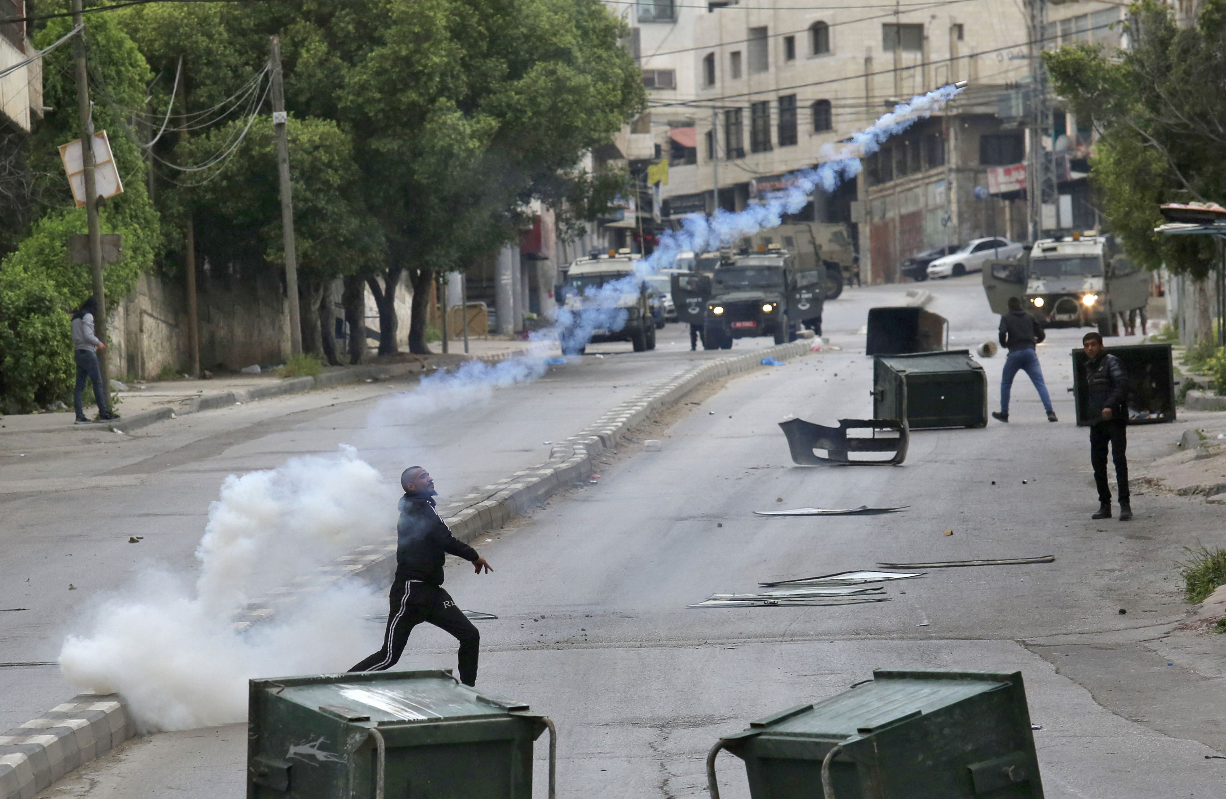 Israeli troops and Palestinians clash near the Jewish pilgrimage site of the Tomb of Joseph in Nablus in the occupied West Bank on April 13, 2022. - Israeli troops shot dead a Palestinian in Nablus on the fifth day of military operations, the Palestinian health ministry said. Israeli public radio said troops entered Nablus to escort Israeli workers who are to repair damage done by Palestinians days ago to a site Jews revere as the tomb of Joseph. Israeli Prime Minister Naftali Bennett has vowed that "we will not abide such an assault on a place that is holy to us -- on the eve of Passover".