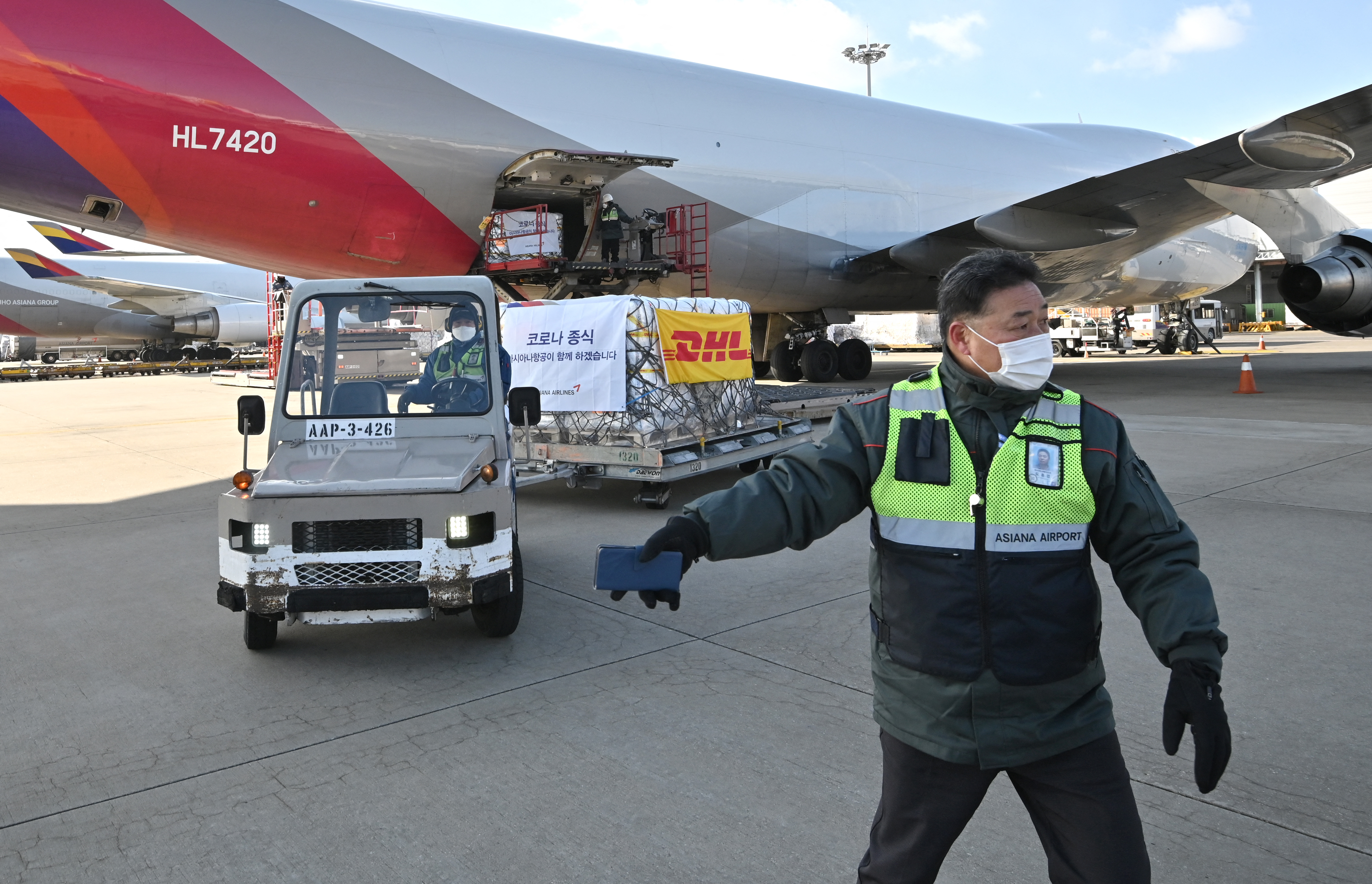 A DHL cargo container of Paxlovid is unloaded from a plane on the tarmac of Seoul's Incheon airport.