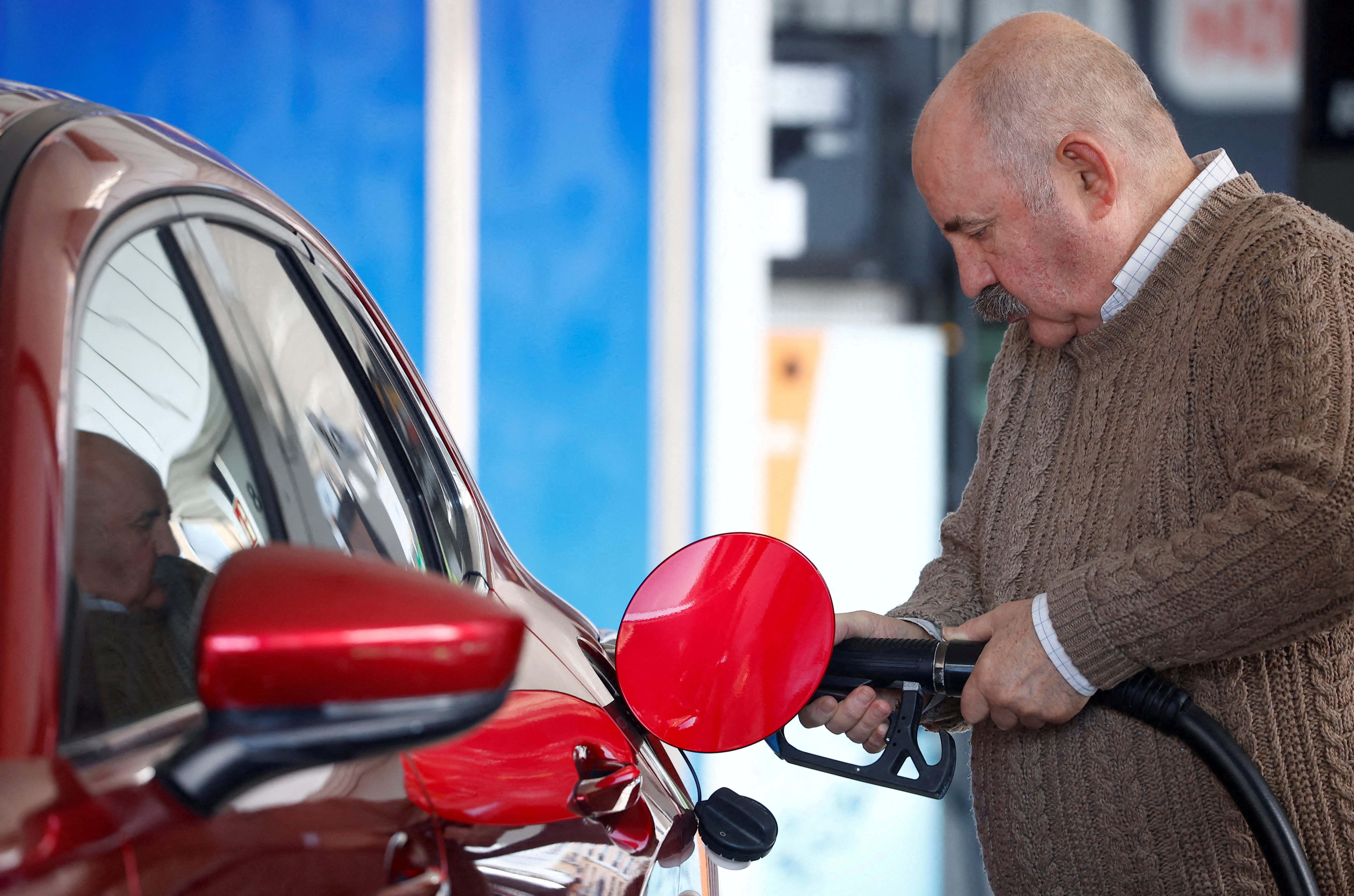 A man fills fuel in his car at a service station during a significant increase in the price of energy in Madrid, Spain
