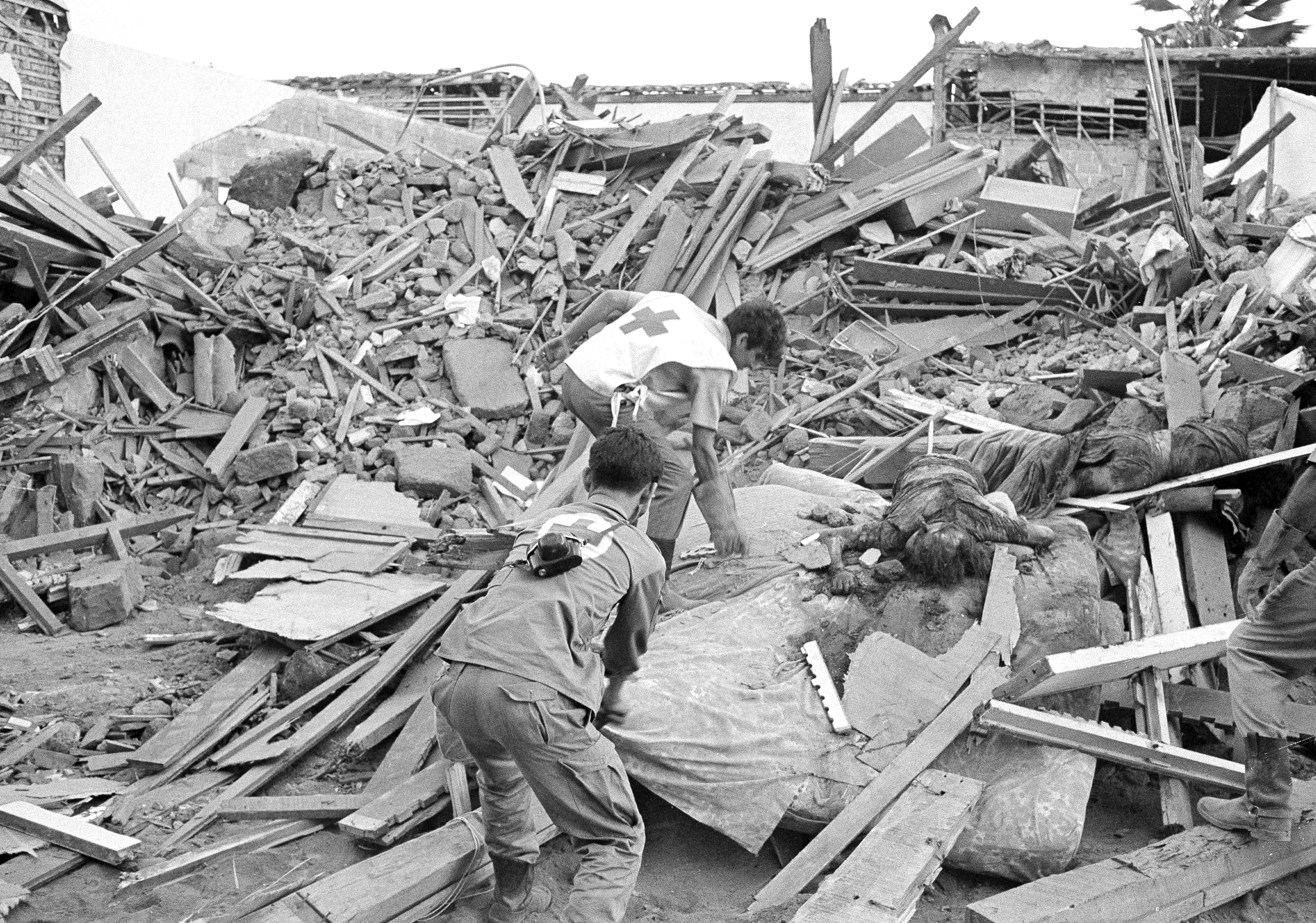 Medics remove the bodies of a woman and her two children