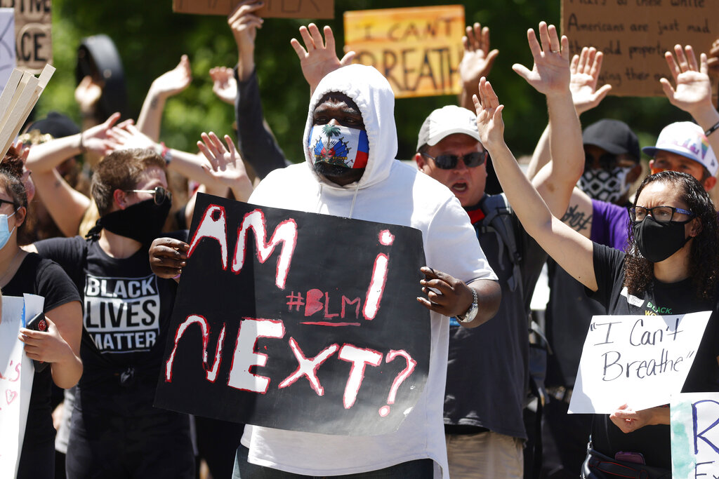 A Black protester holds a placard that says 'Am i next? #BLM' outside the State Capitol in Denver over the death of George Floyd.