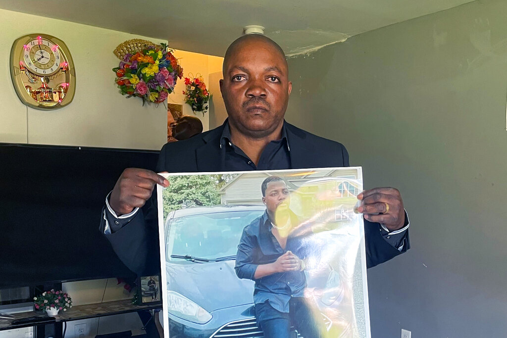 Peter Lyoya holds up a picture of his son, Patrick