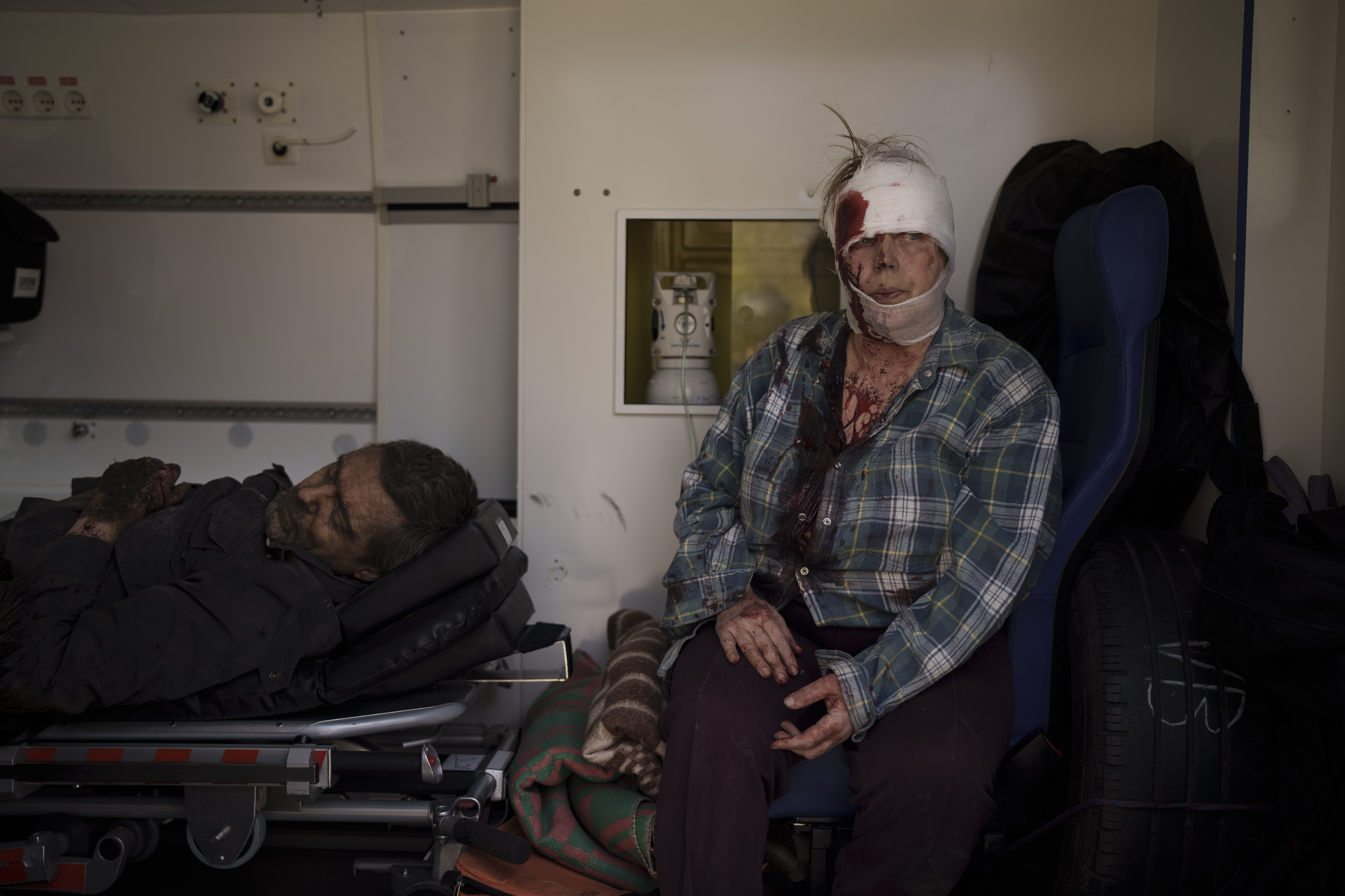 Injured civilians sit in an ambulance before being taken to a hospital after a Russian attack in Kharkiv,