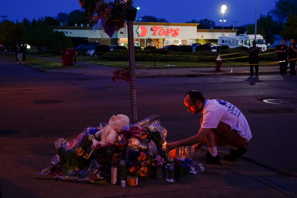 A person pays his respects outside the scene of a shooting at a supermarket, in Buffalo, N.Y.