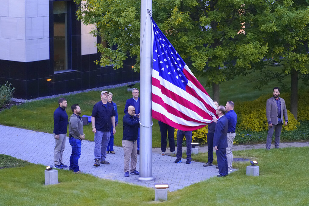 Employees of US embassy in Ukraine raise the US national flag at the US embassy, as Russia's attack on Ukraine continues, in Kyiv.