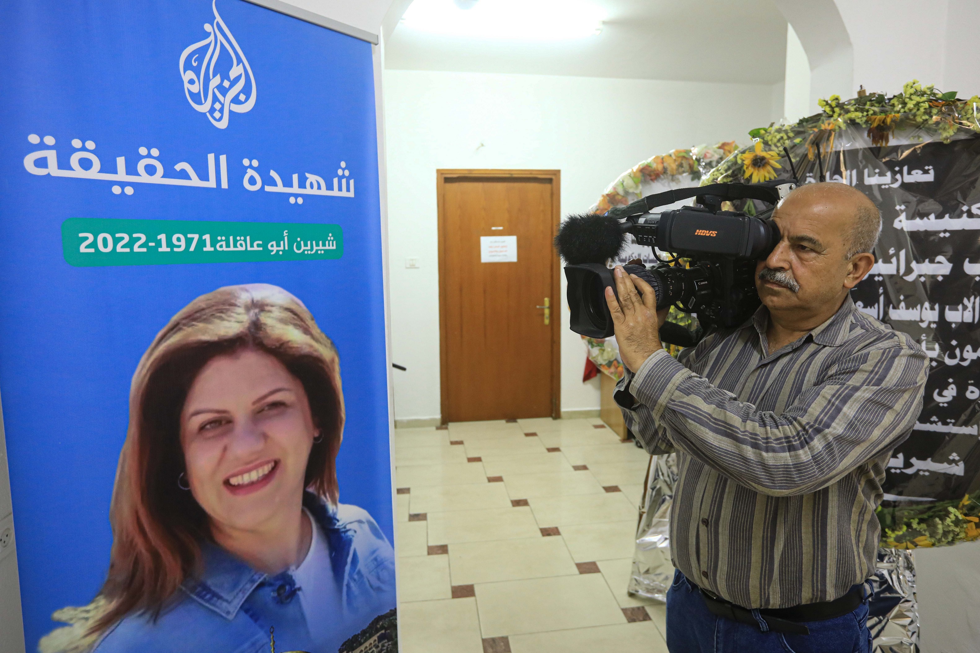 Al Jazeera senior cameraman holds his camera.