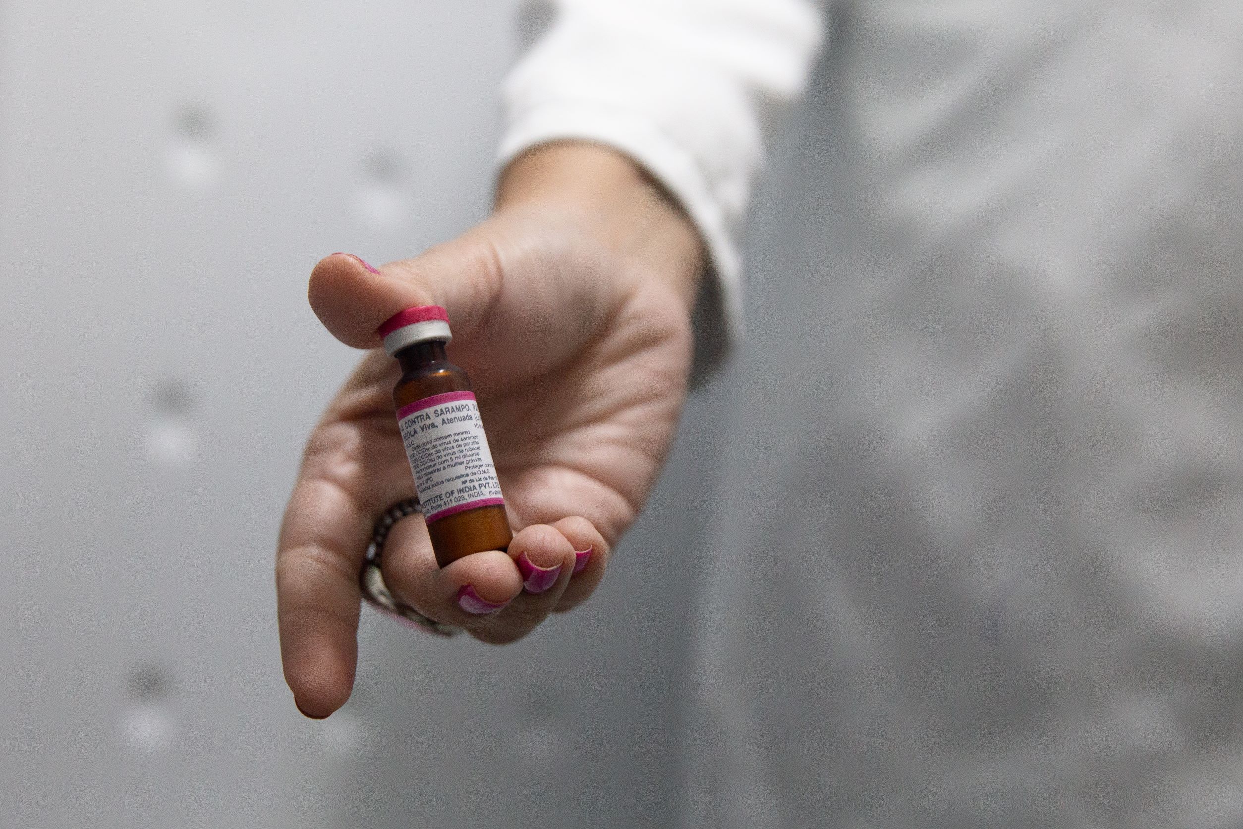 A doctor in Brazil holds a vial of measles vaccine