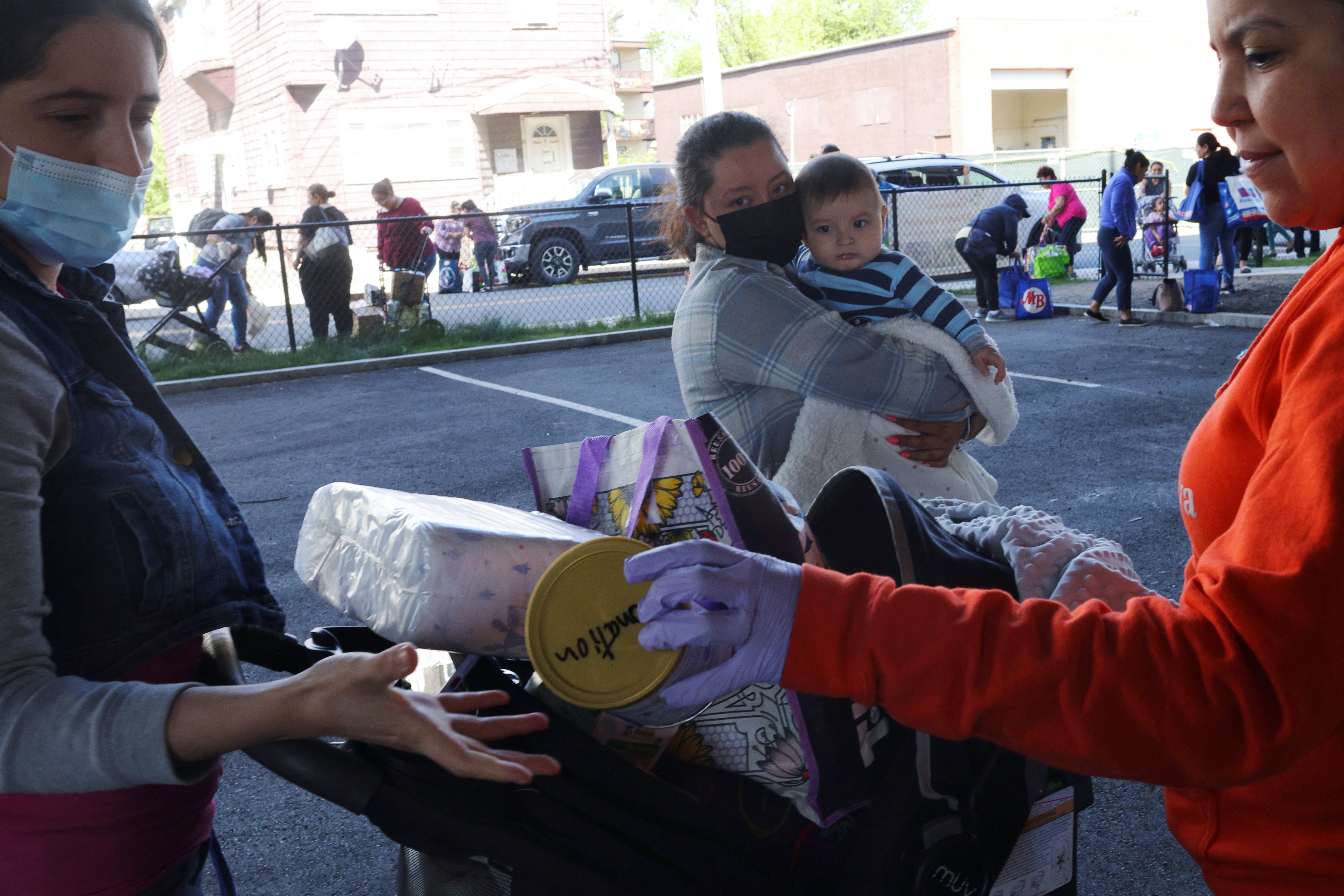 Six month-old Jared Ramos watches as his mother receives free baby formula