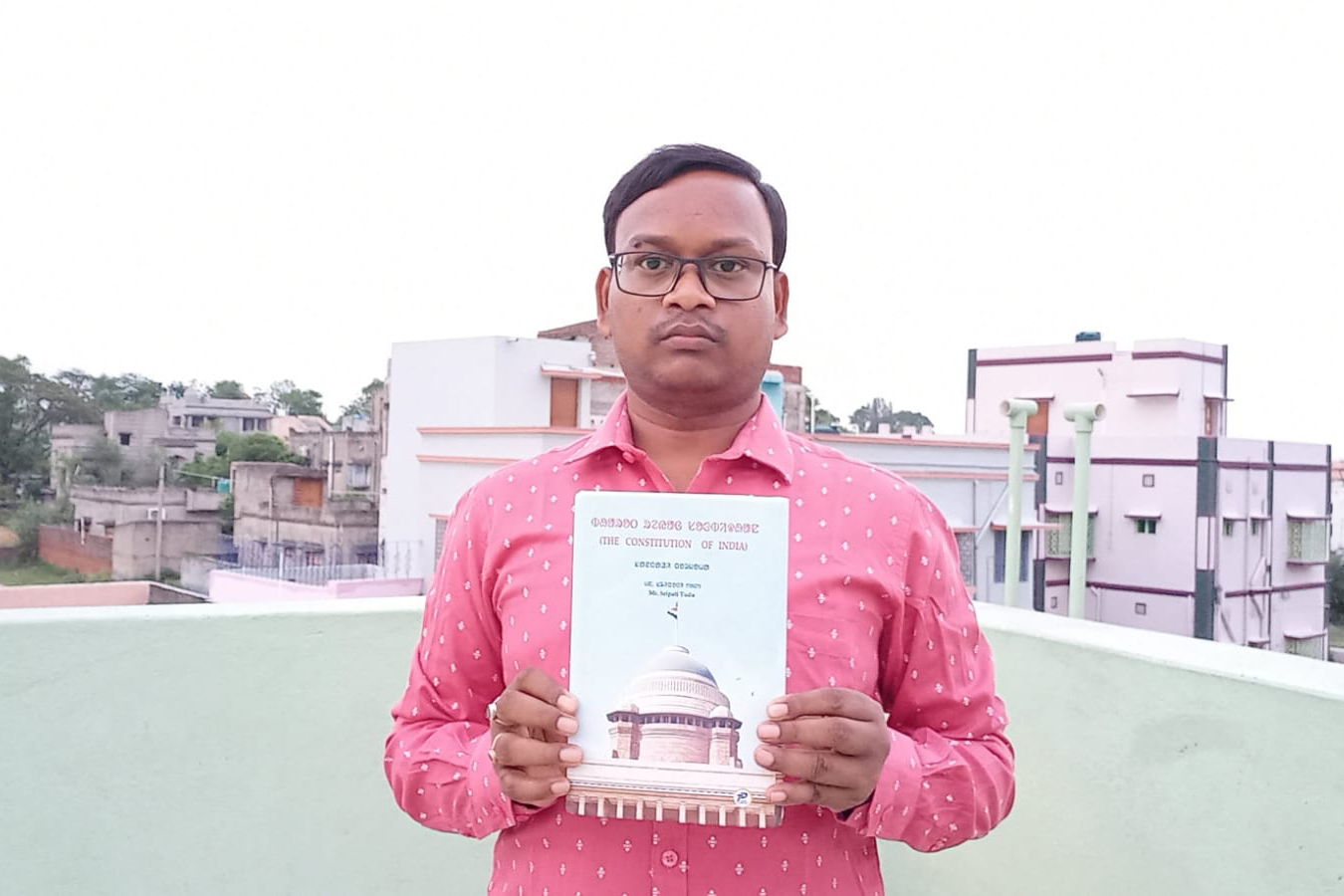 Tudu holding a copy of his translation of the Indian constitution into Santali [Courtesy: Sripati Tudu]