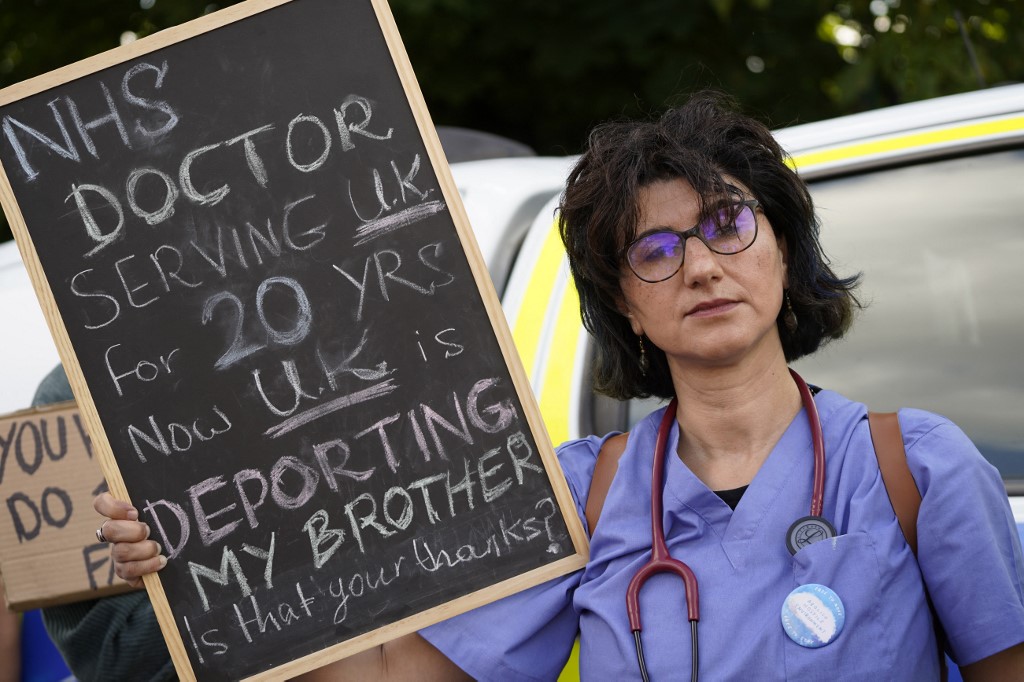 A protester holds up a placard at a gathering close to the Brook House Immigration Removal Centre beside Gatwick Airport