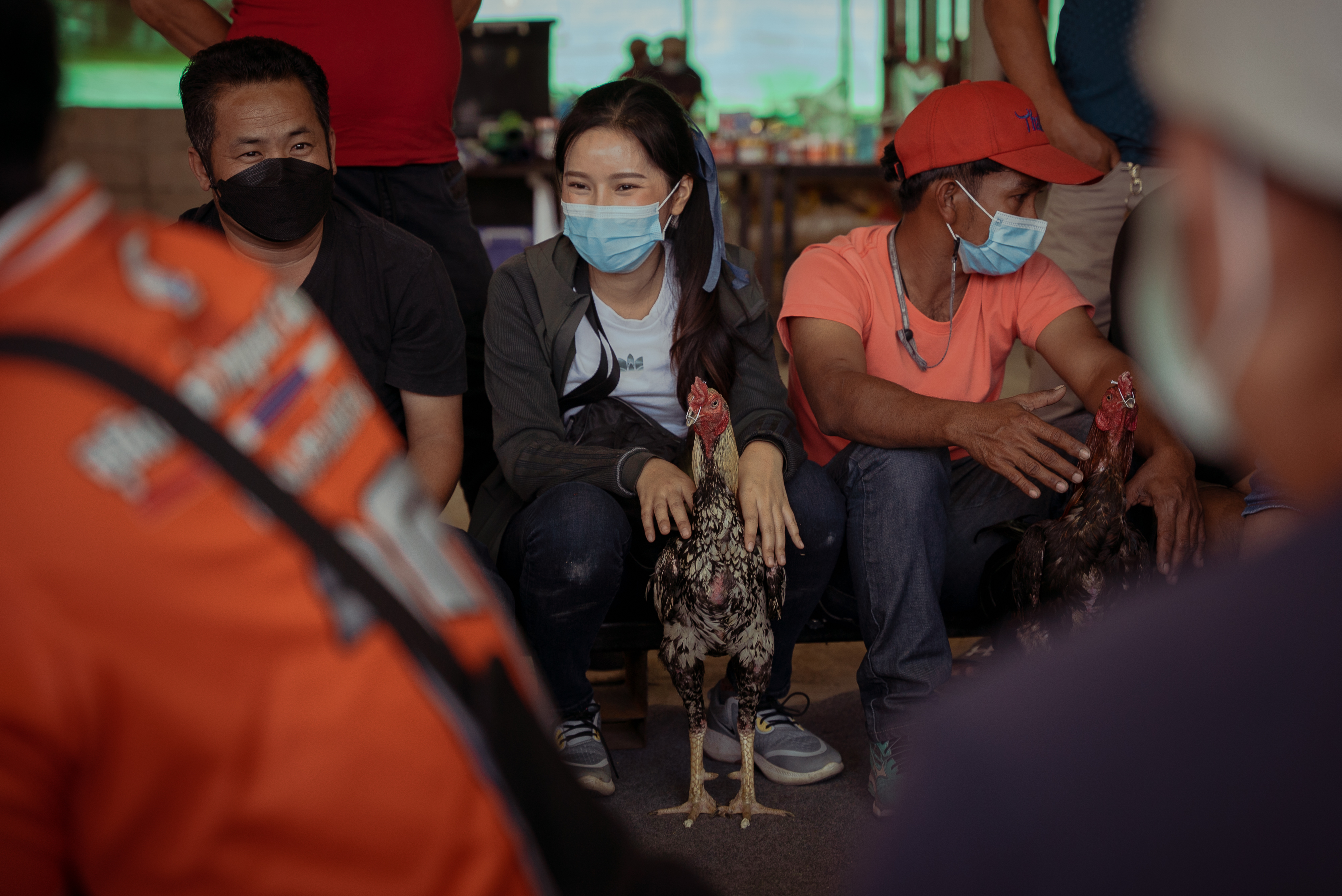 Mod sits among the other cockerel owners as they wait to pair their birds for a fight