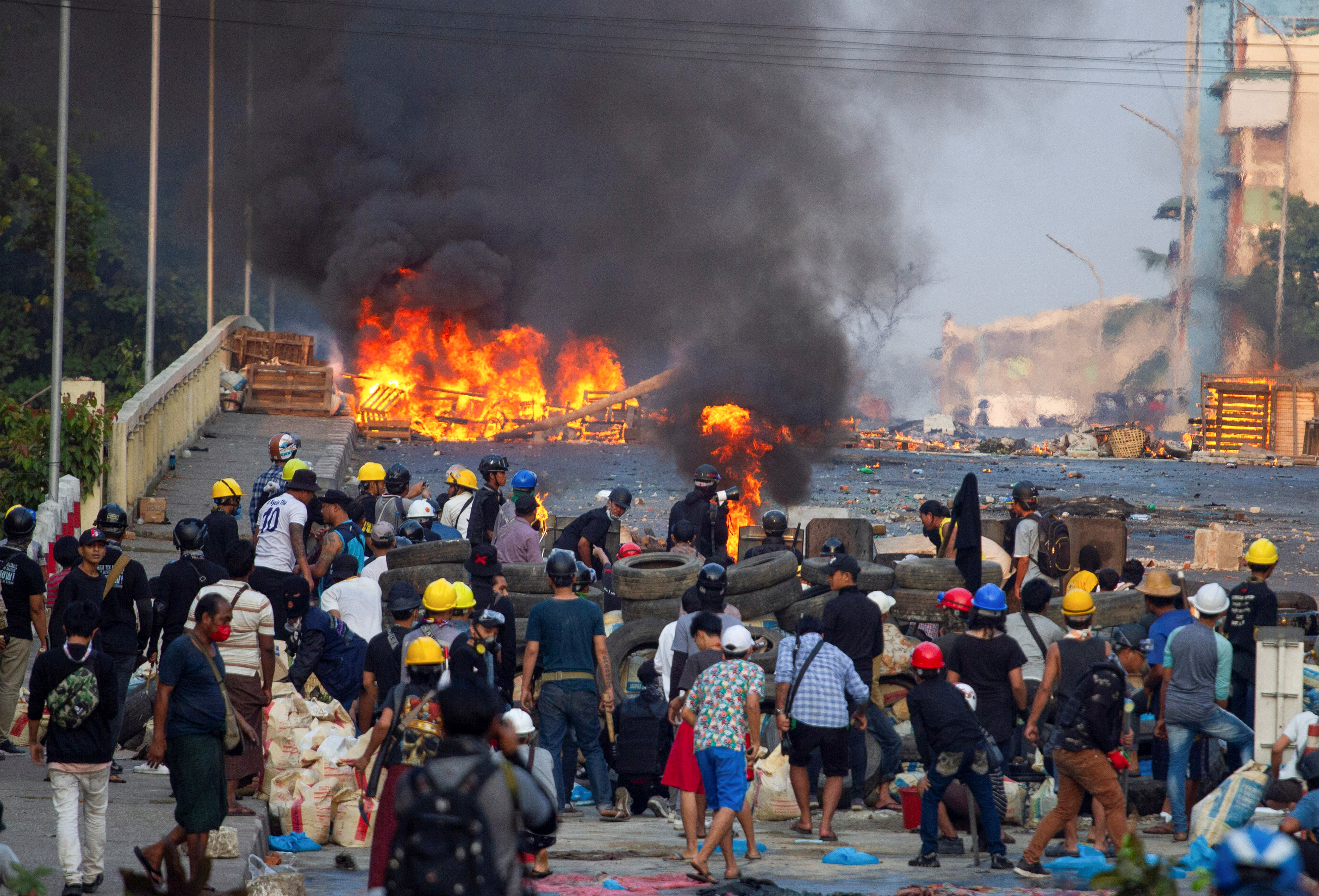 Anti-coup protesters stand at a barricade
