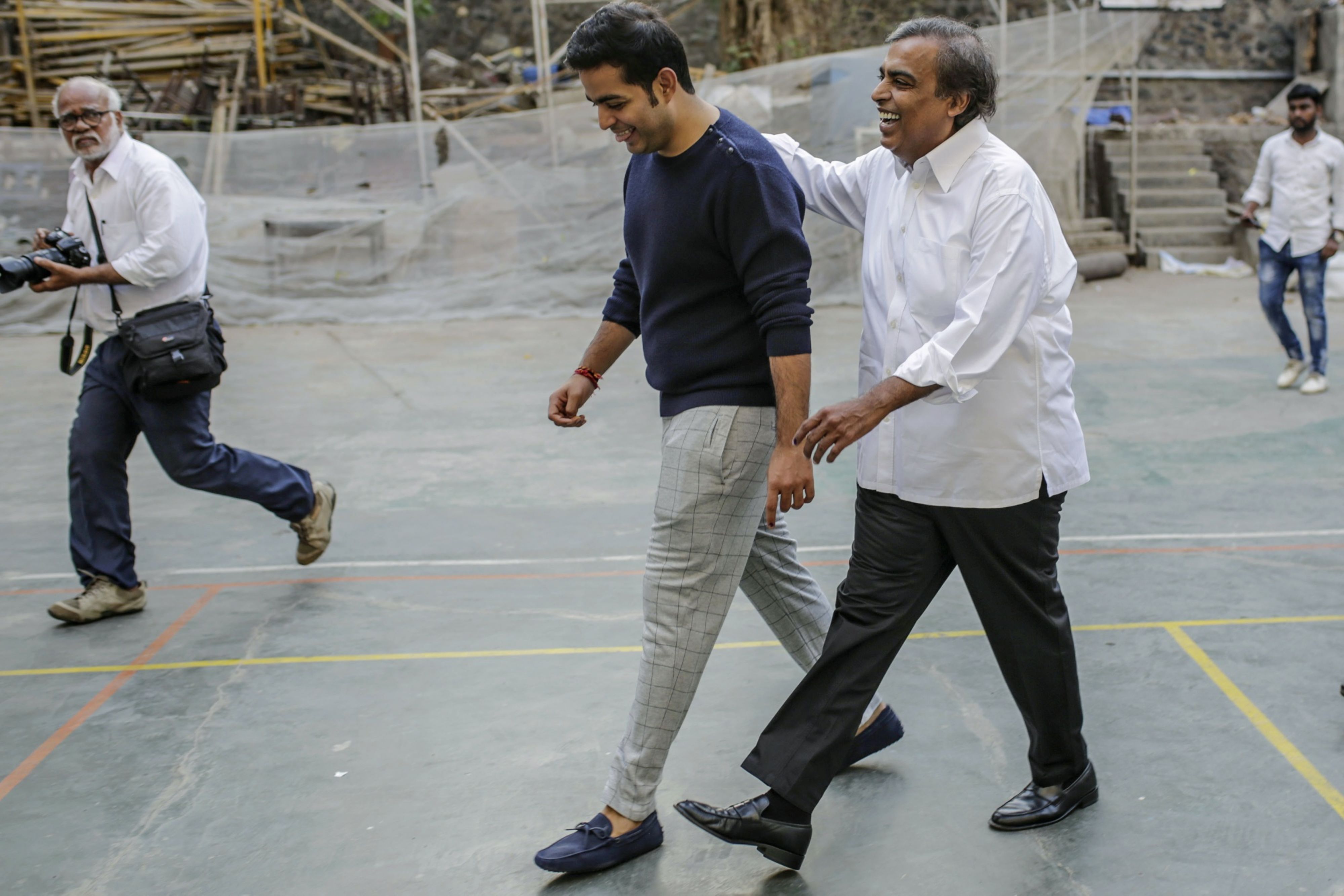 Mukesh Ambani, chairman and managing director of Reliance Industries Ltd., right, his son Akash Ambani, depart a polling station during the fourth phase of voting for national elections in Mumbai, India