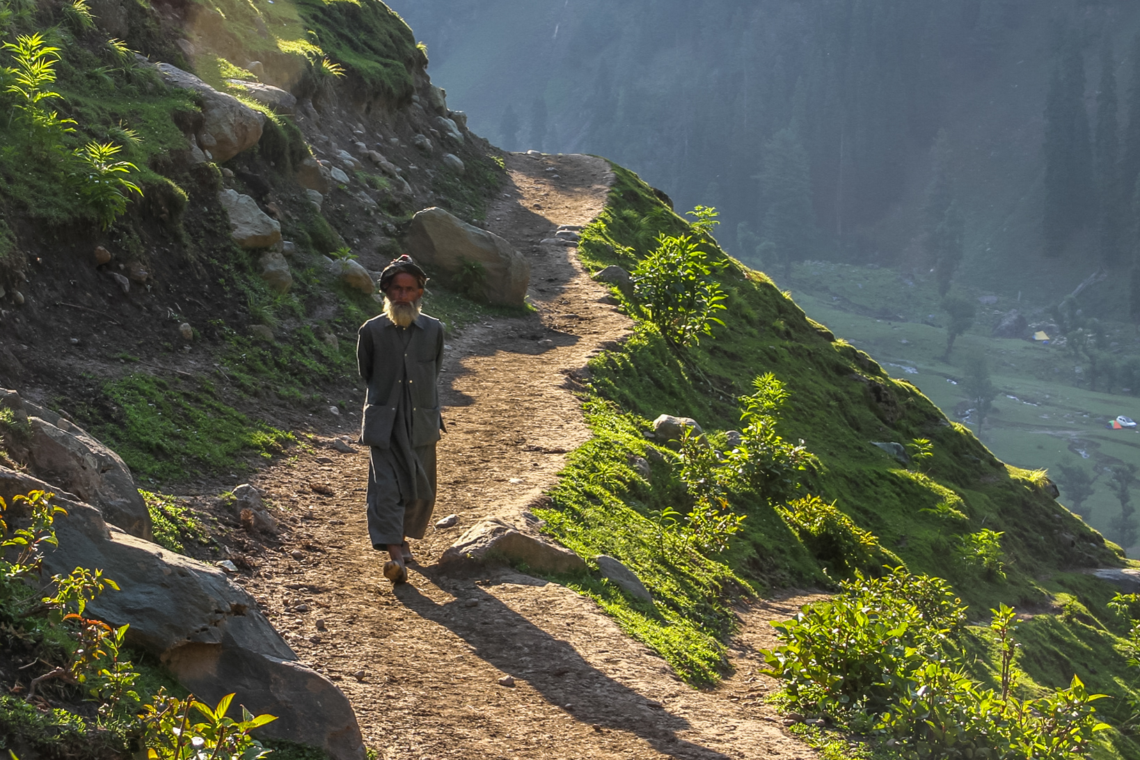 A man from Braaden walks along a horse path to the hamlet. Since there is no road to the village, residents either use horses or walk to collect supplies from Aru market