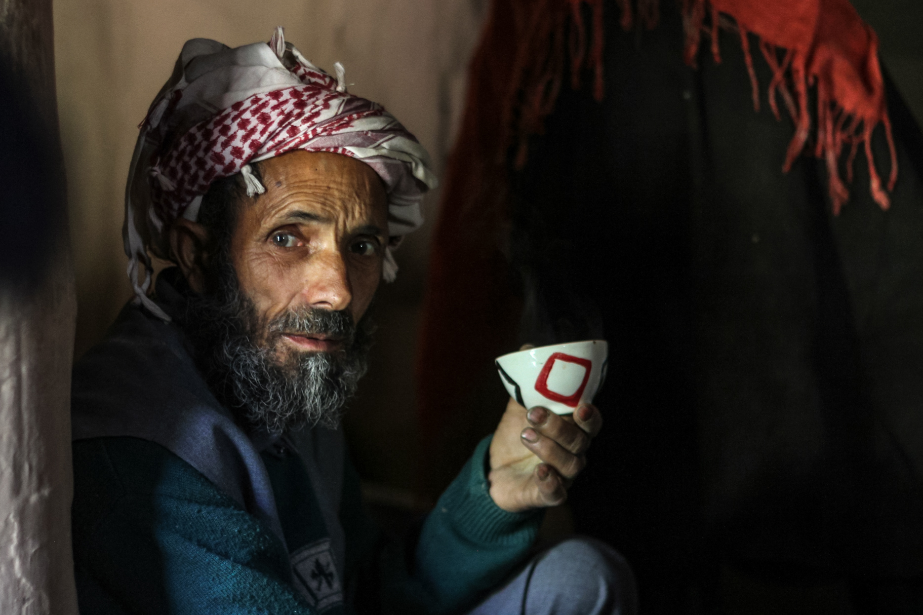 Abdul Karim having a cup of tea inside his mud house in Braaden, near Aru in Indian-administered Kashmir