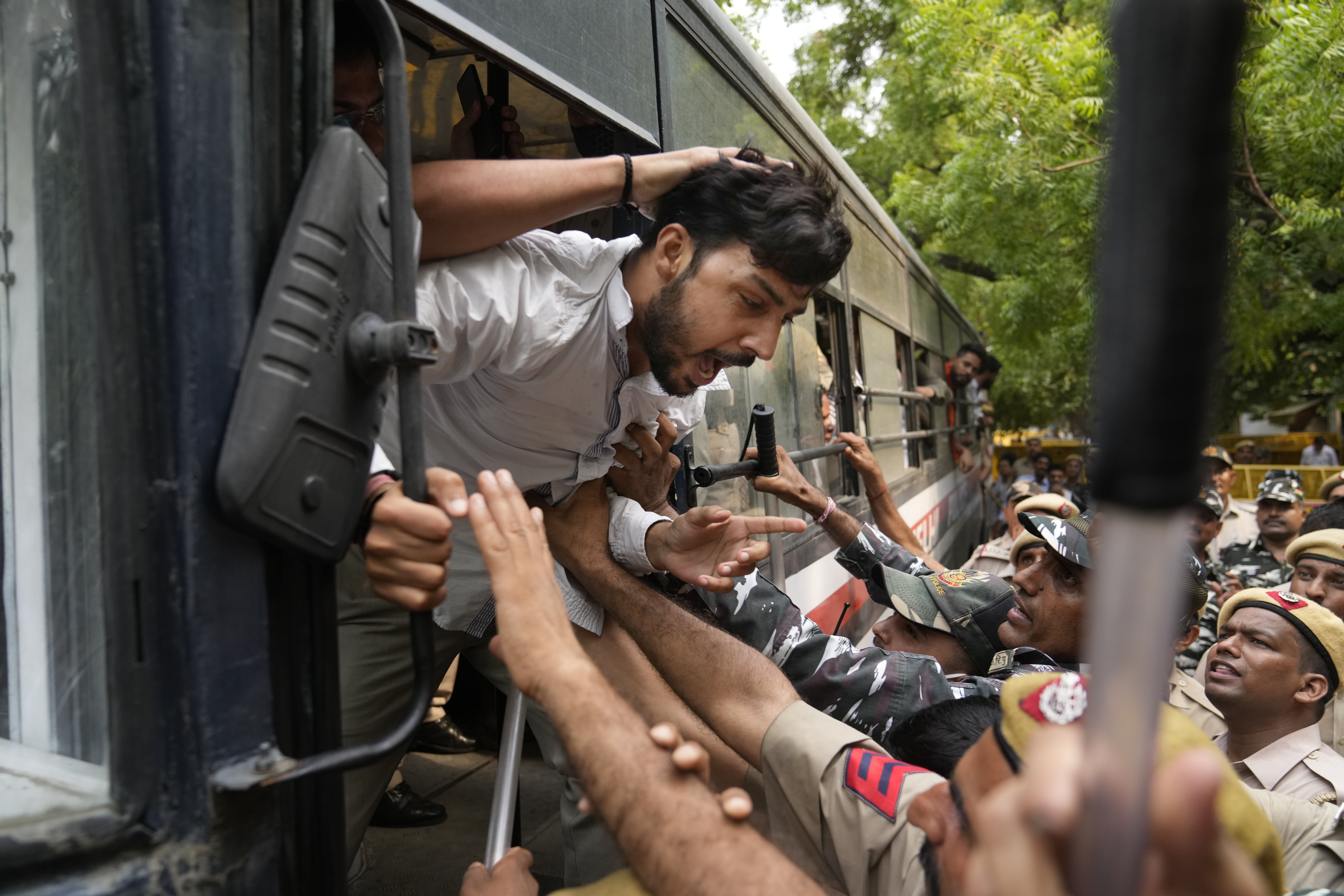 Policemen detain activists from right-wing Hindu groups protesting against Teli’s killing in Udaipur