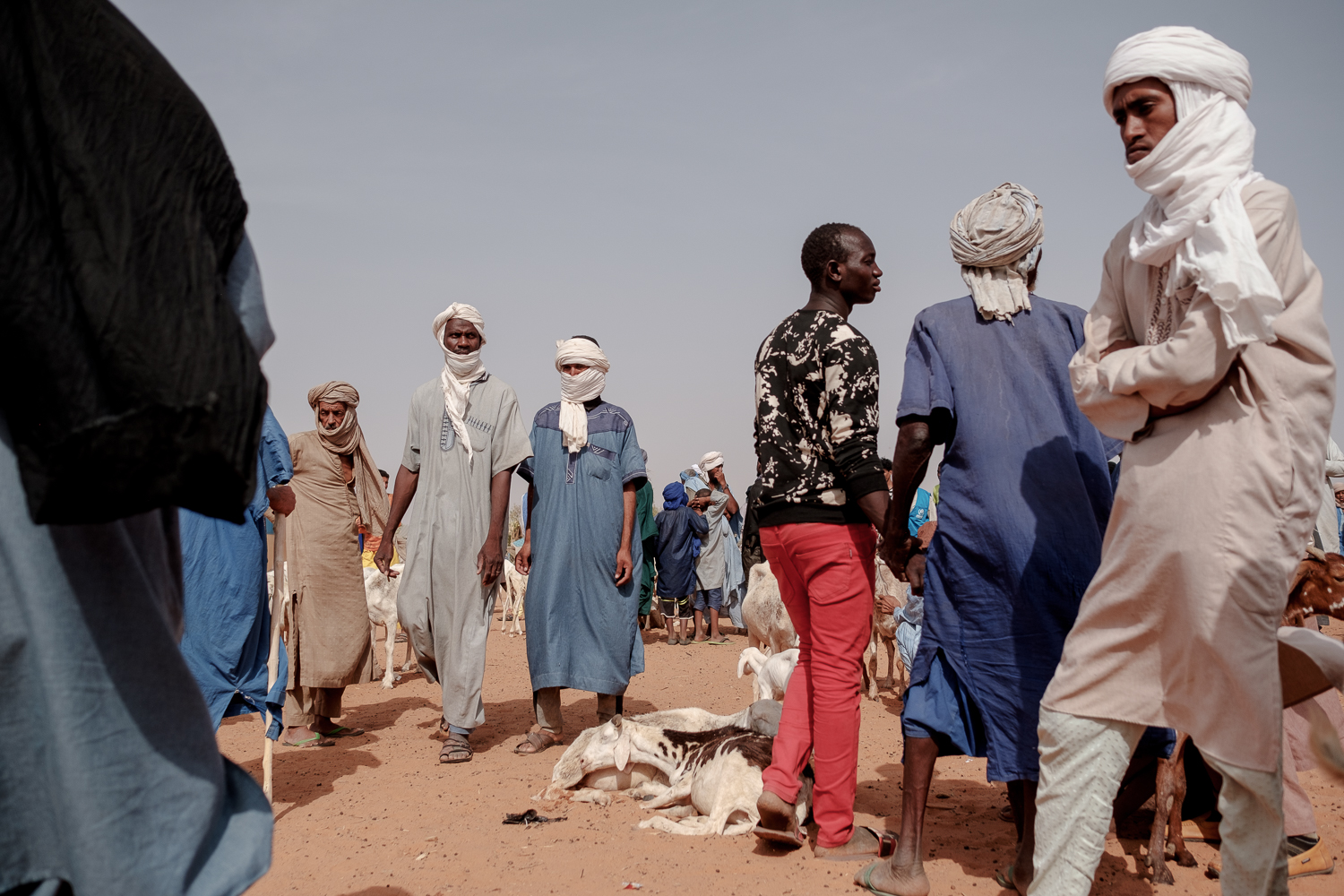Men walk around the weekly sheep market in Mbera reffugee camp in Bassikonou