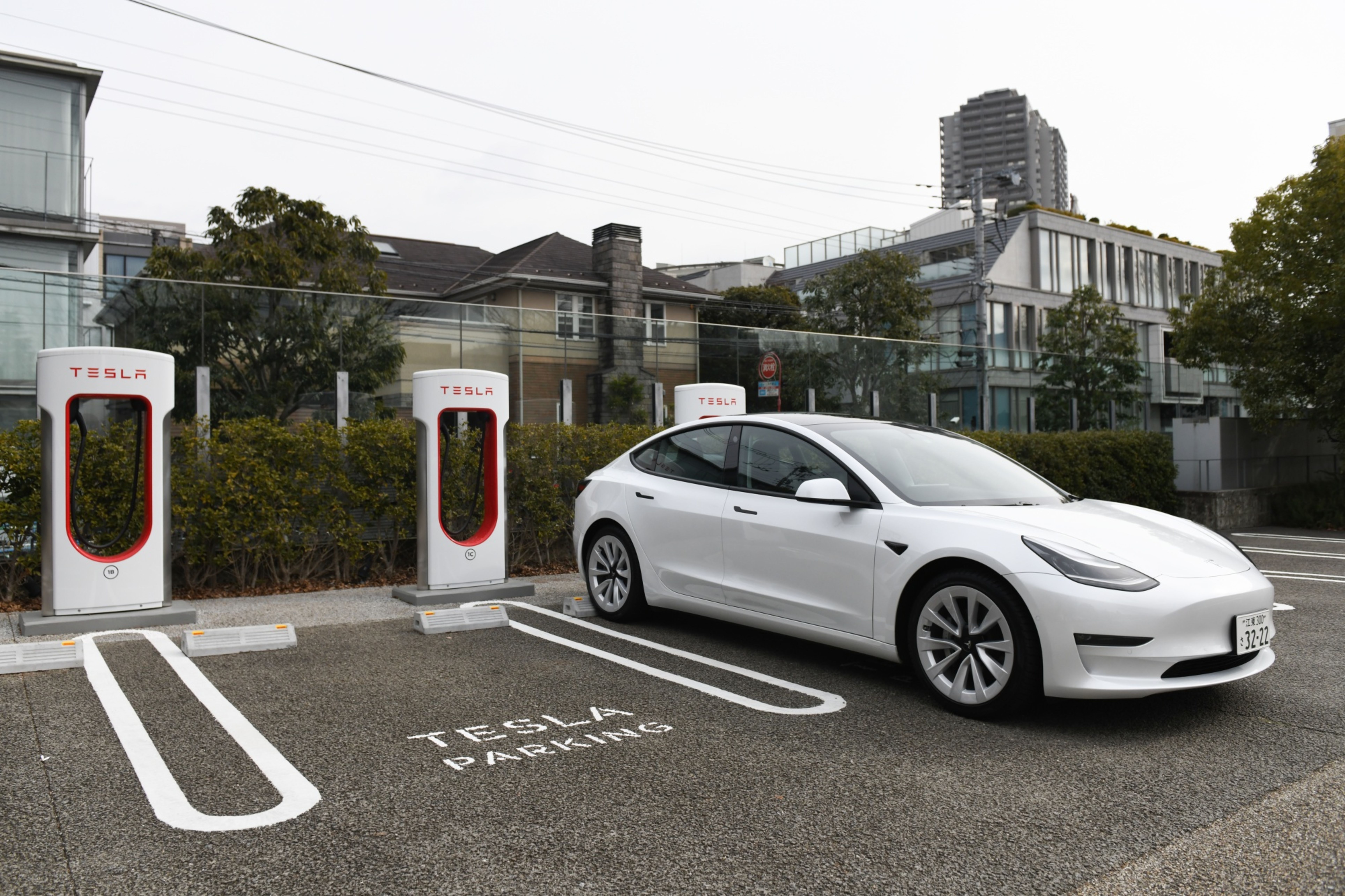 Tesla car at a charging station in a parking lot.