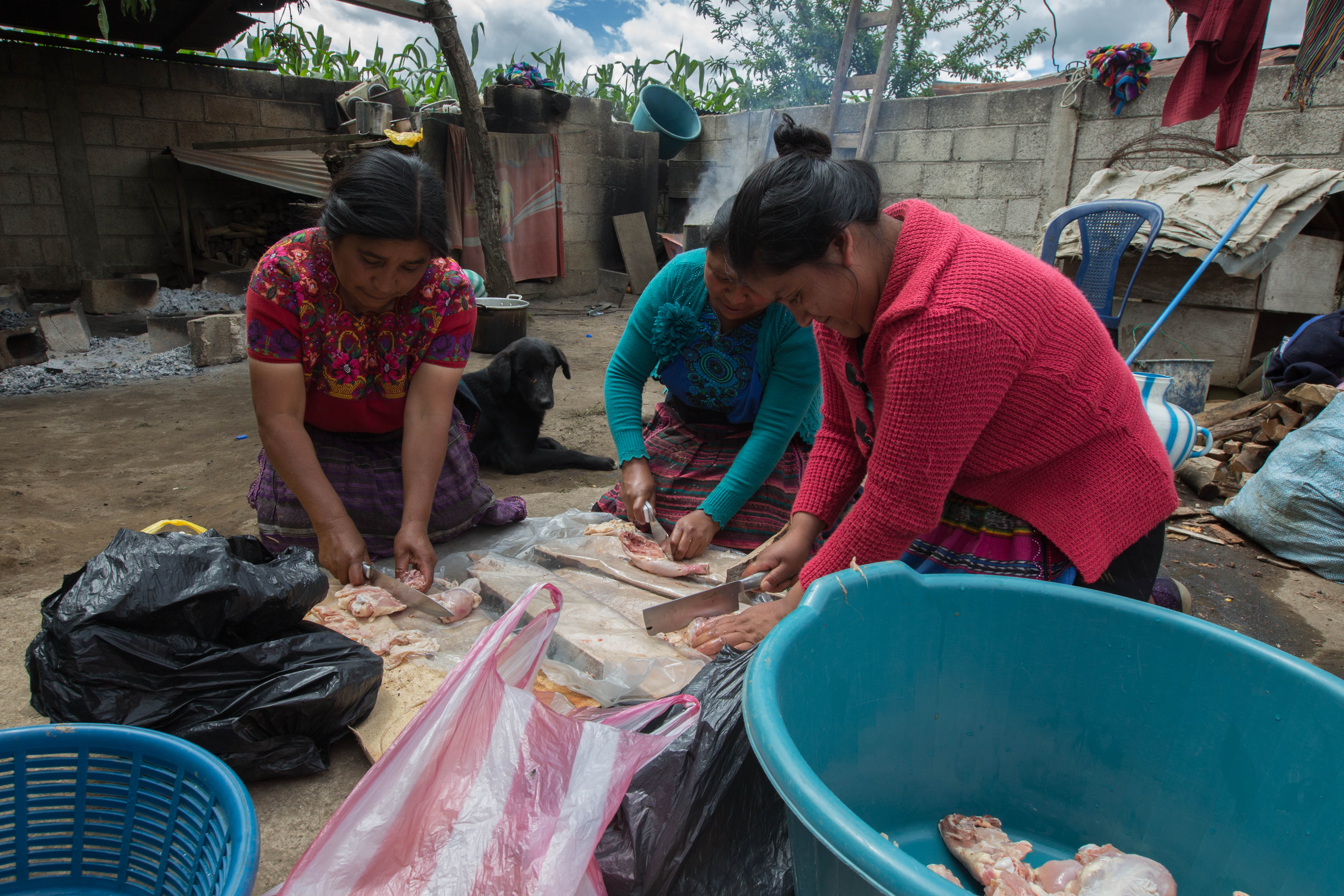 Women prepare chicken for visitors in the family home of Pascual Melvin Guachia in Tzucubal, July 2, 2022