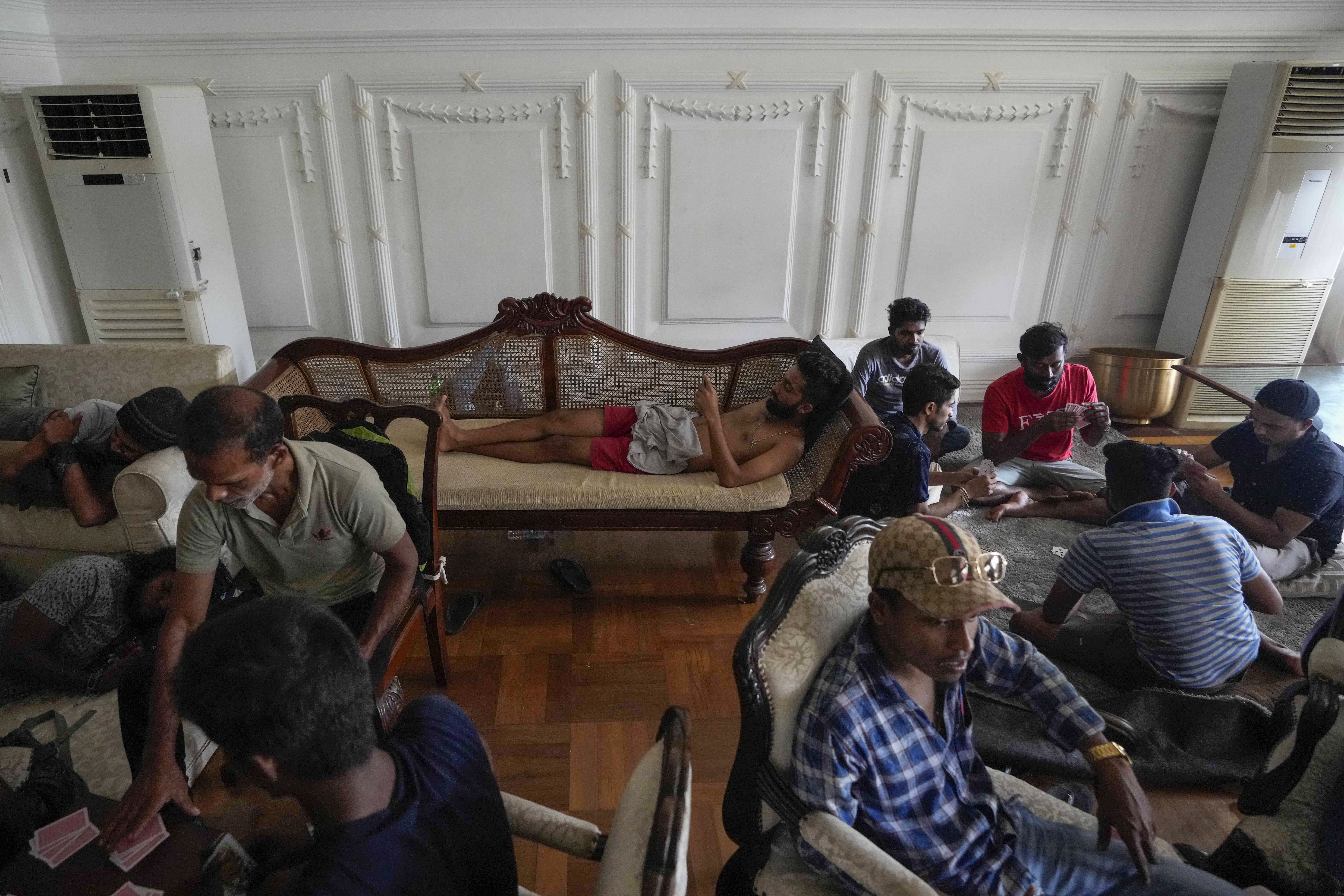 Protesters stay and play cards in prime minister's official residence a day after it was stormed in Colombo, Sri Lanka
