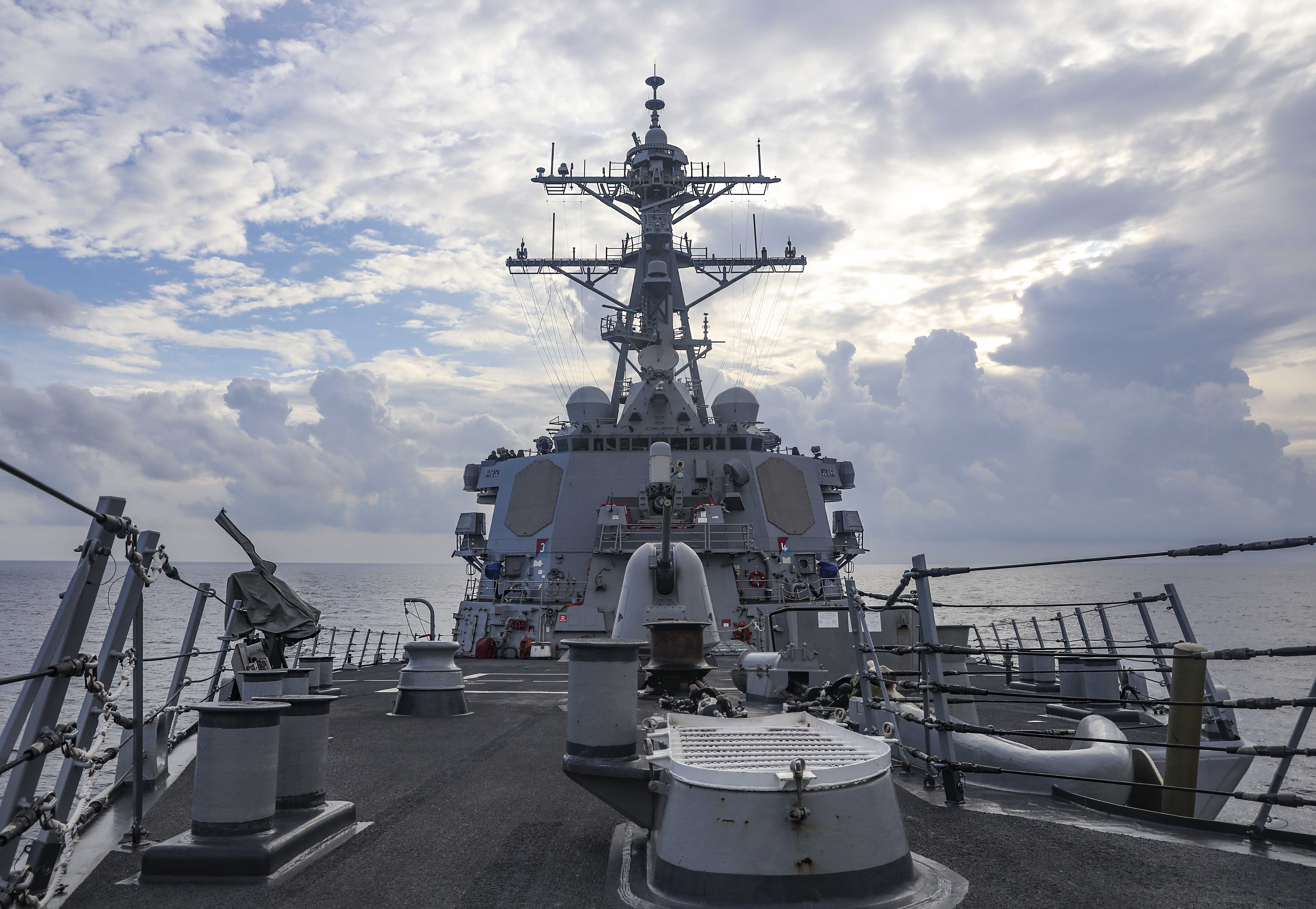 The deck and bridge of the USS Benfold against a blue sky and white clouds on the South China Sea