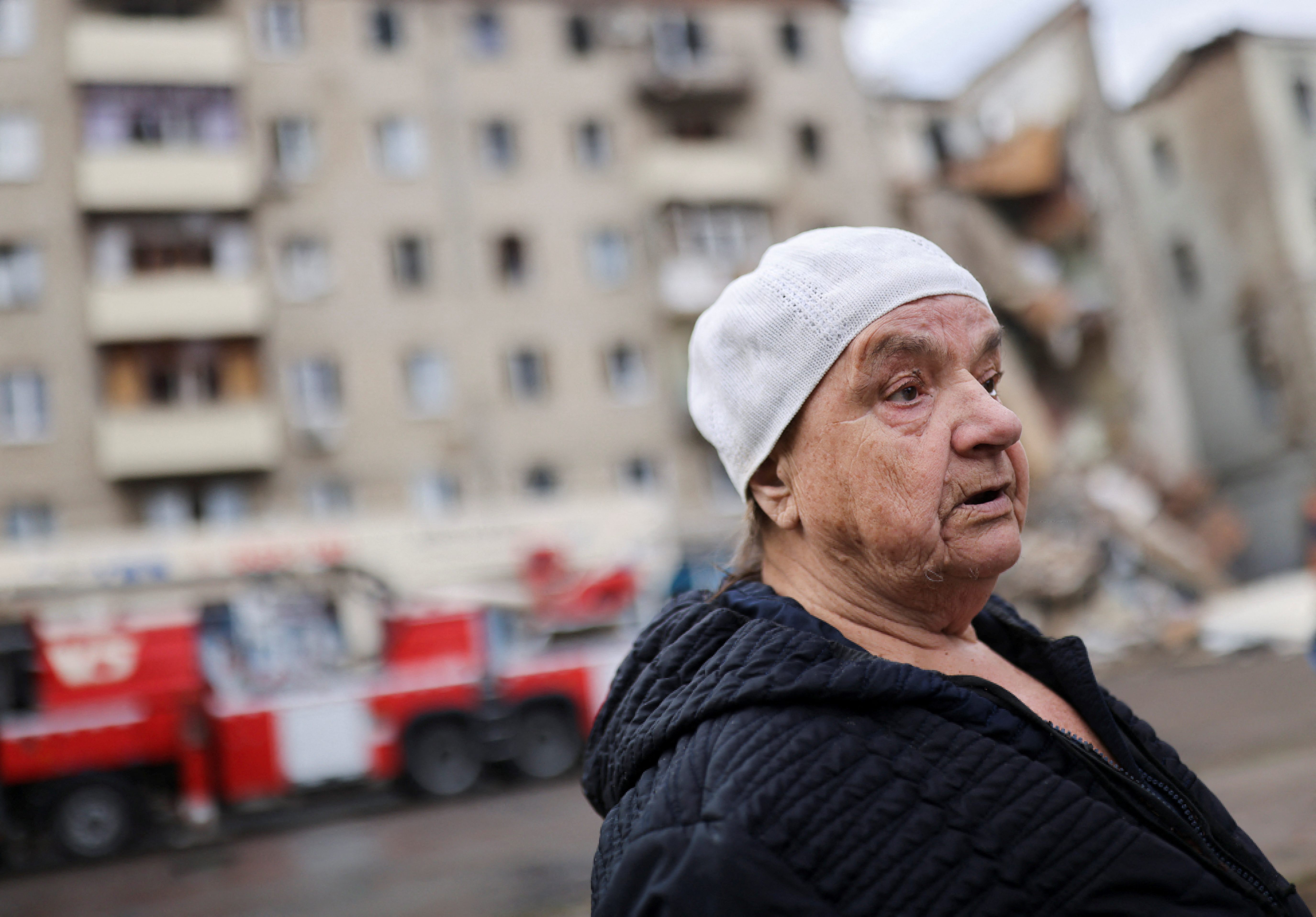 Valentina Popovichuk, who was rescued from residential building after Russian shelling, stands in front of her destroyed apartment block in Kharkiv, Ukraine.