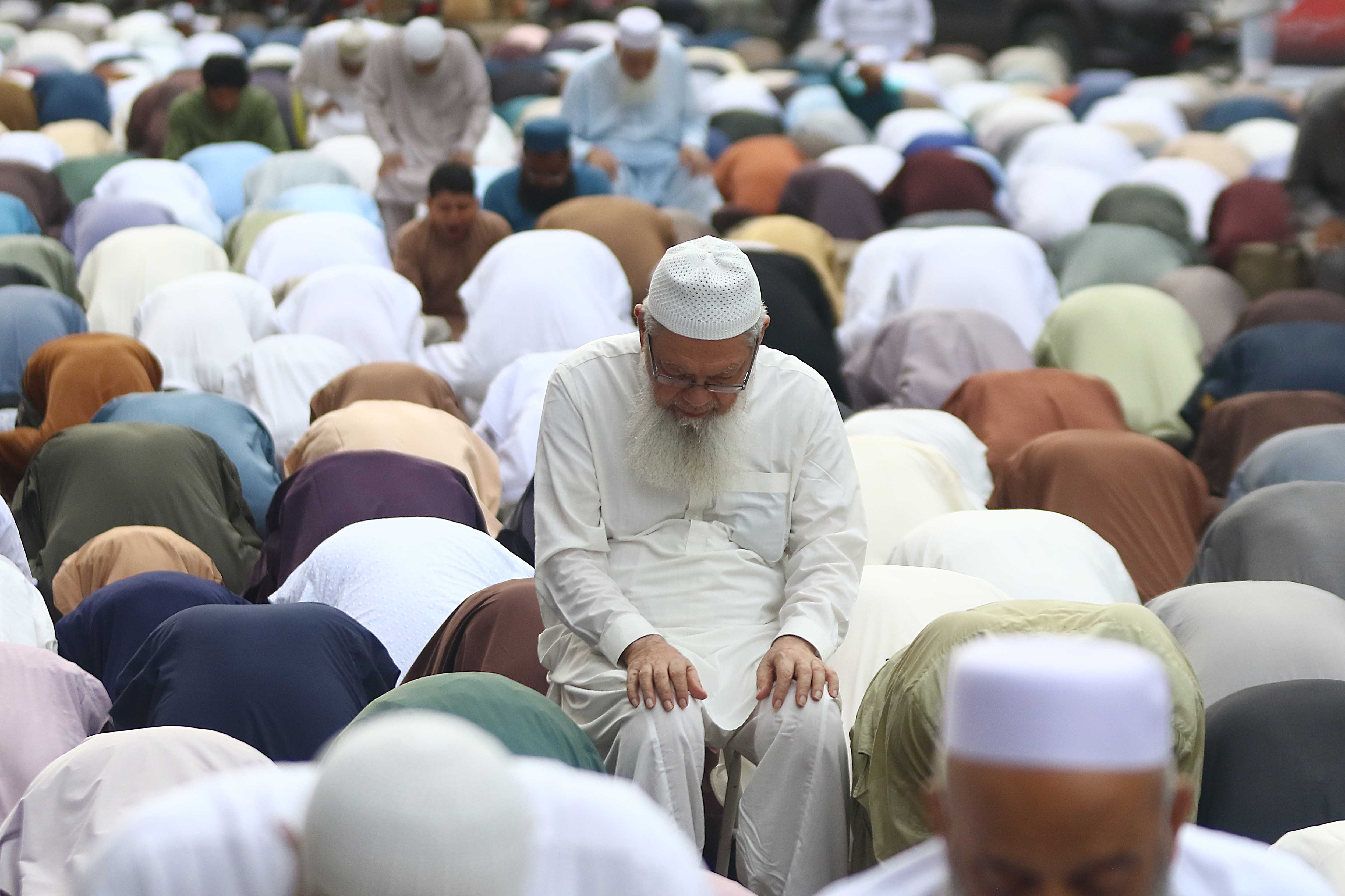 Pakistani Muslims perform Eid al-Adha prayers on road side during Eid al-Adha in Karachi