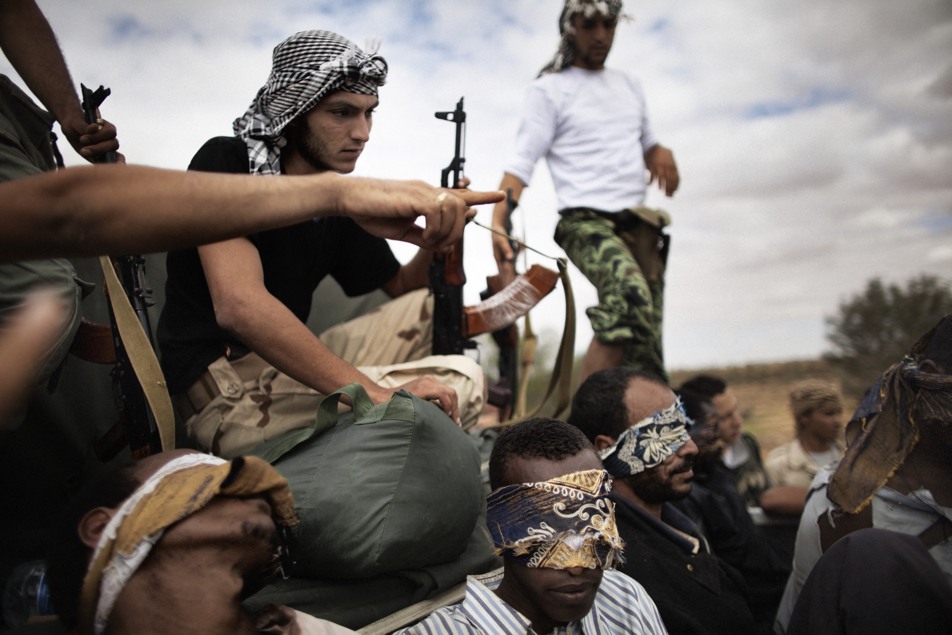 Fighters with the National Transitional Council from the Tripoli Brigade guard blindfolded prisoners, allegedly foreign fighters with loyalist troops, outside the restive city of Bani Walid.