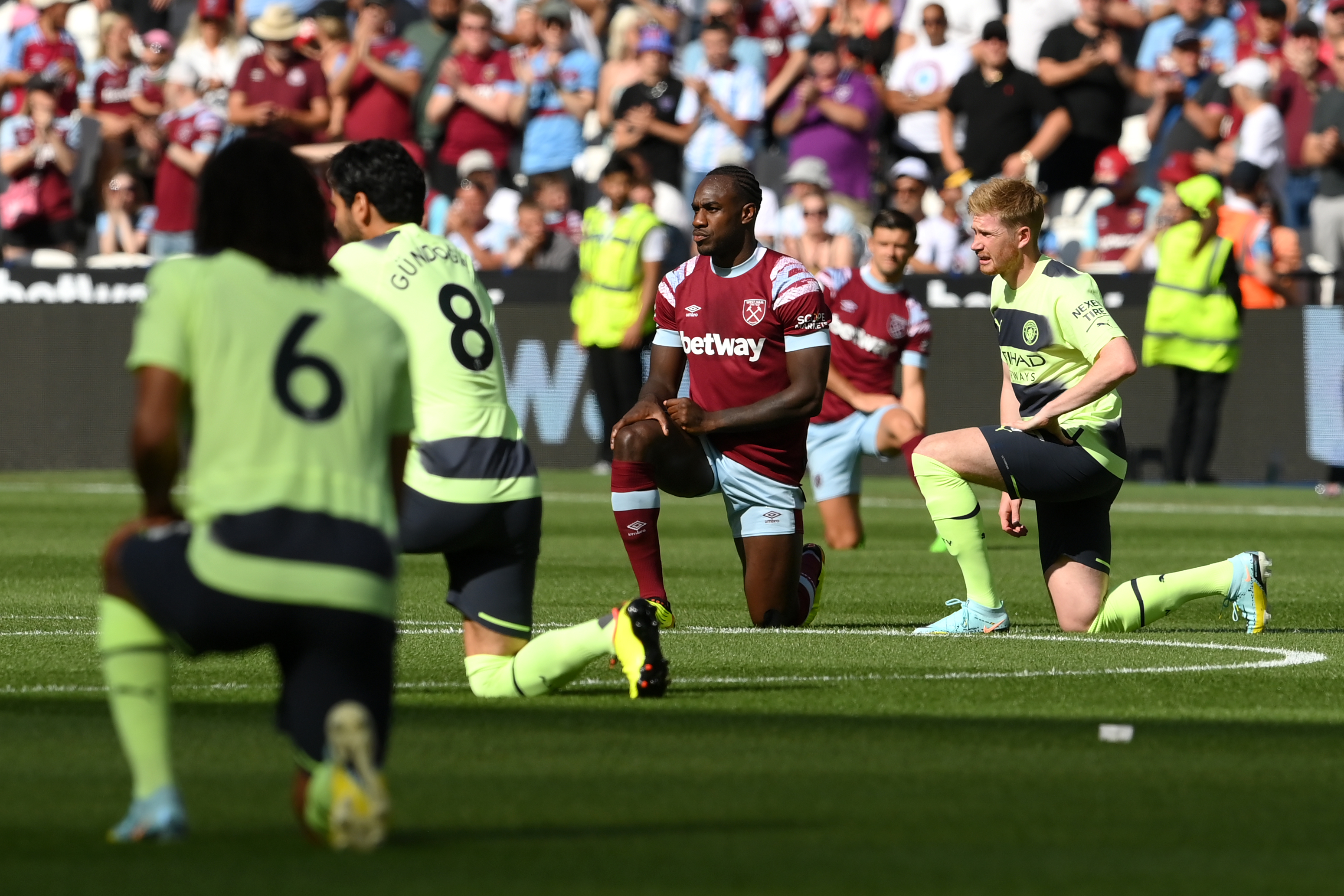 Players from Manchester City and West Ham United take the knee before the start of their game on August 7, 2022, in protest against racism.