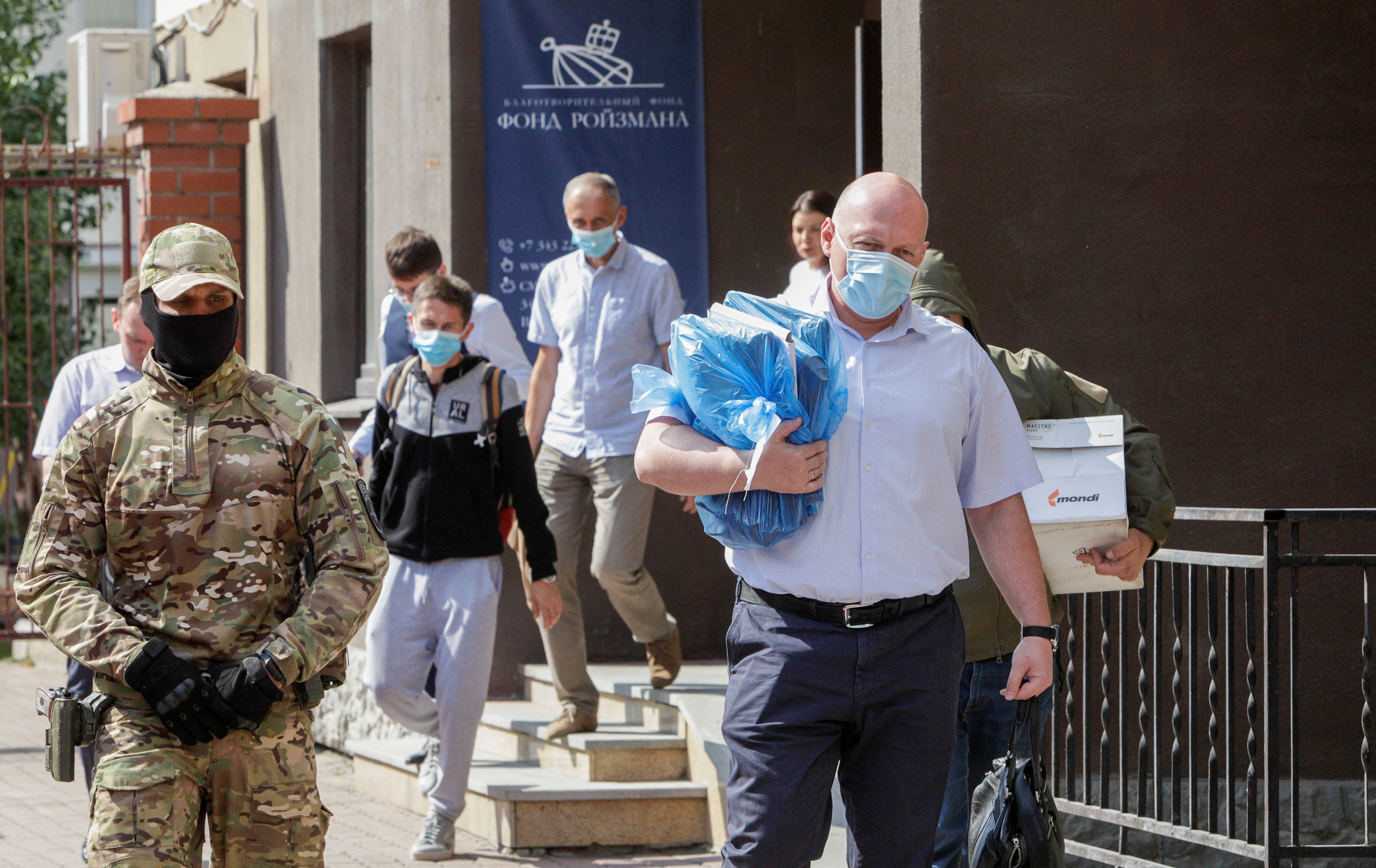 Russian law enforcement officers and investigators walk out of the office of Roizman Charity Fund, after its founder and politician Yevgeny Roizman was reportedly detained