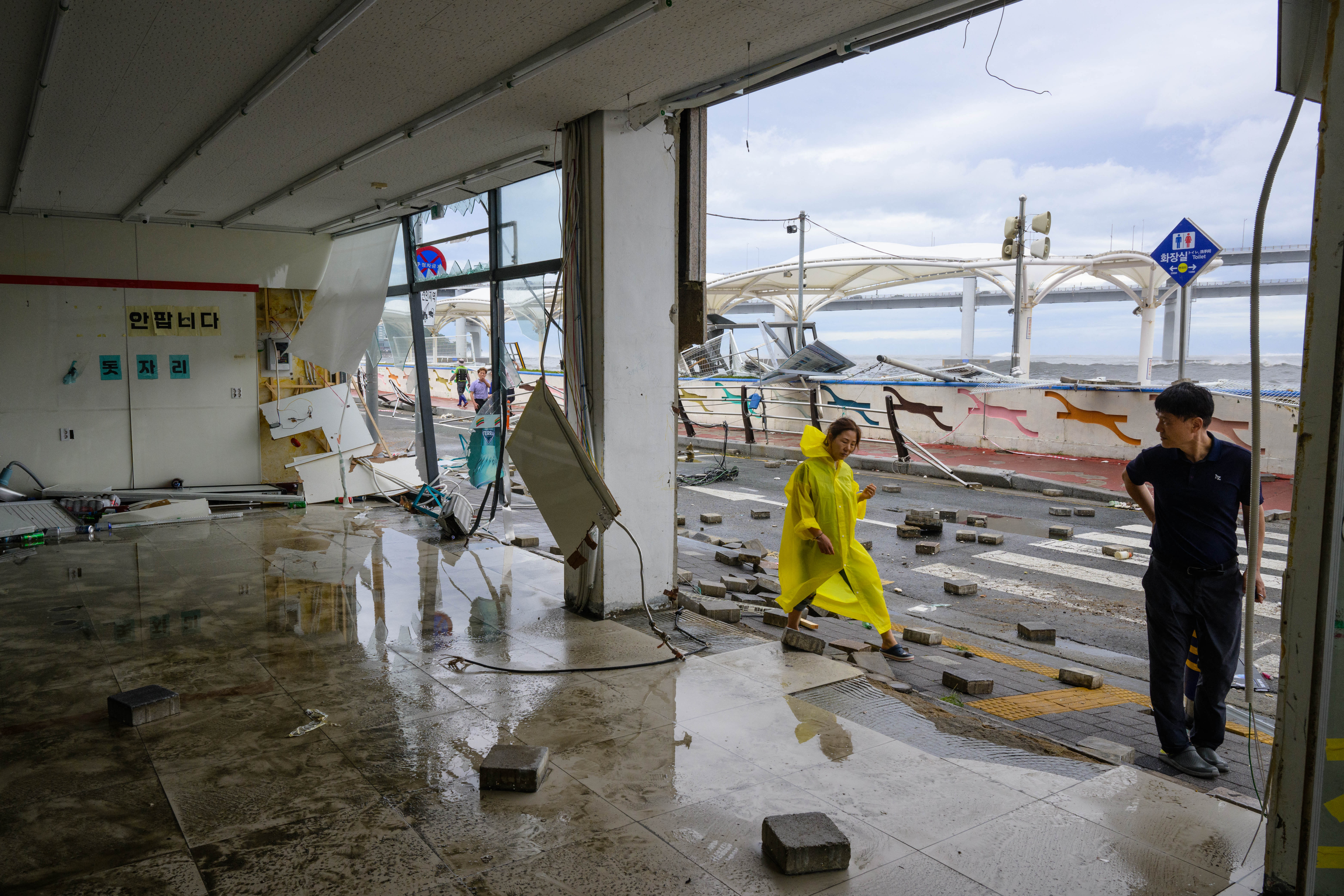 Pedestrians walk past a shop t