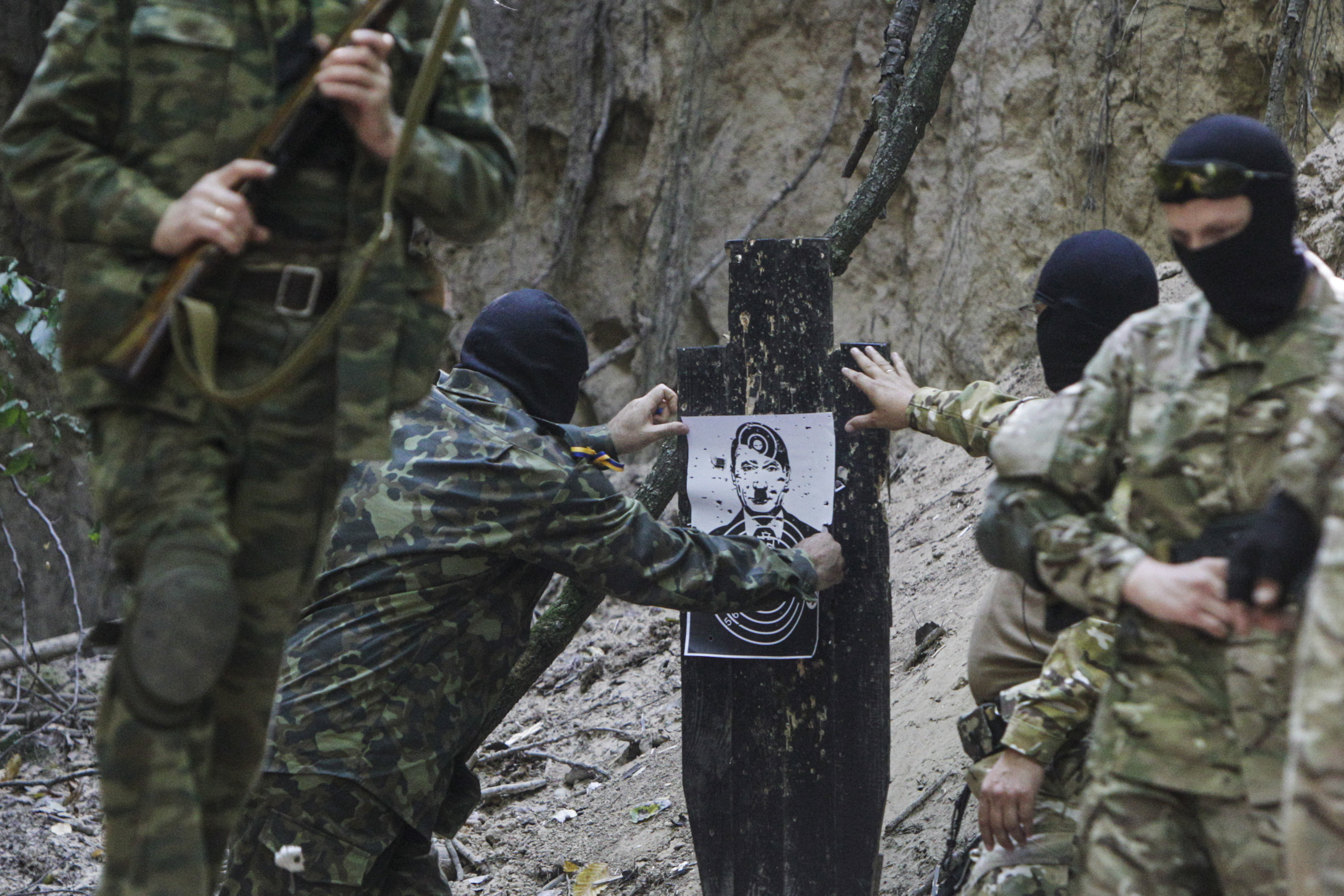 Pro-Ukrainian fighters look at a target with bullet impacts during guerilla tactics training in a forest outside Kiev September 11, 2014. The group said that it is preparing for possible guerrilla war in case of Russian invasion. REUTERS/Valentyn Ogirenko (UKRAINE - Tags: POLITICS CIVIL UNREST CONFLICT MILITARY)
